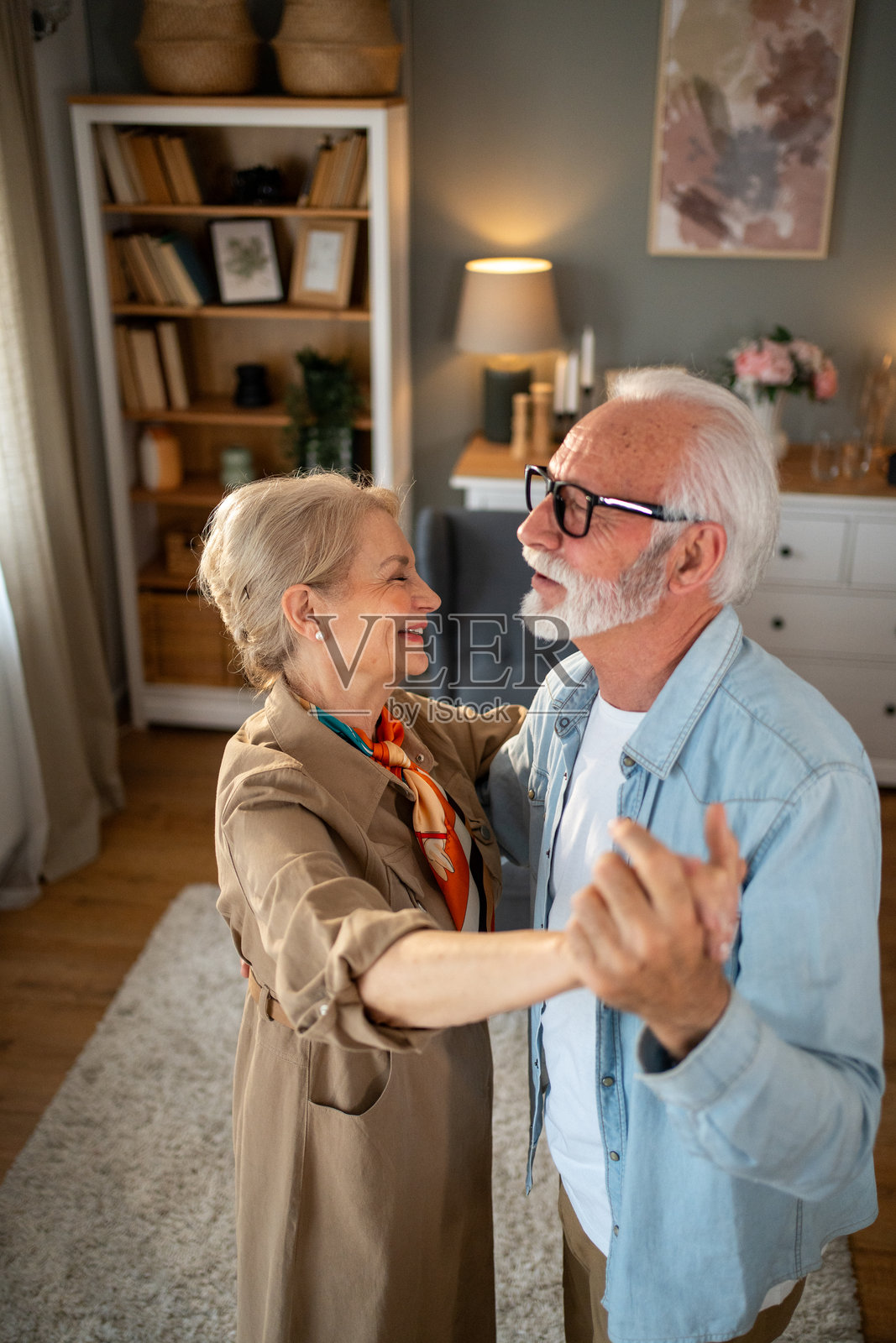 快乐的老年夫妇在客厅里共舞照片摄影图片