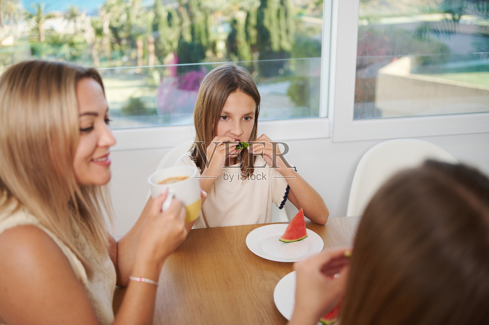 快乐的家庭在明亮的厨房里一起享用西瓜照片摄影图片