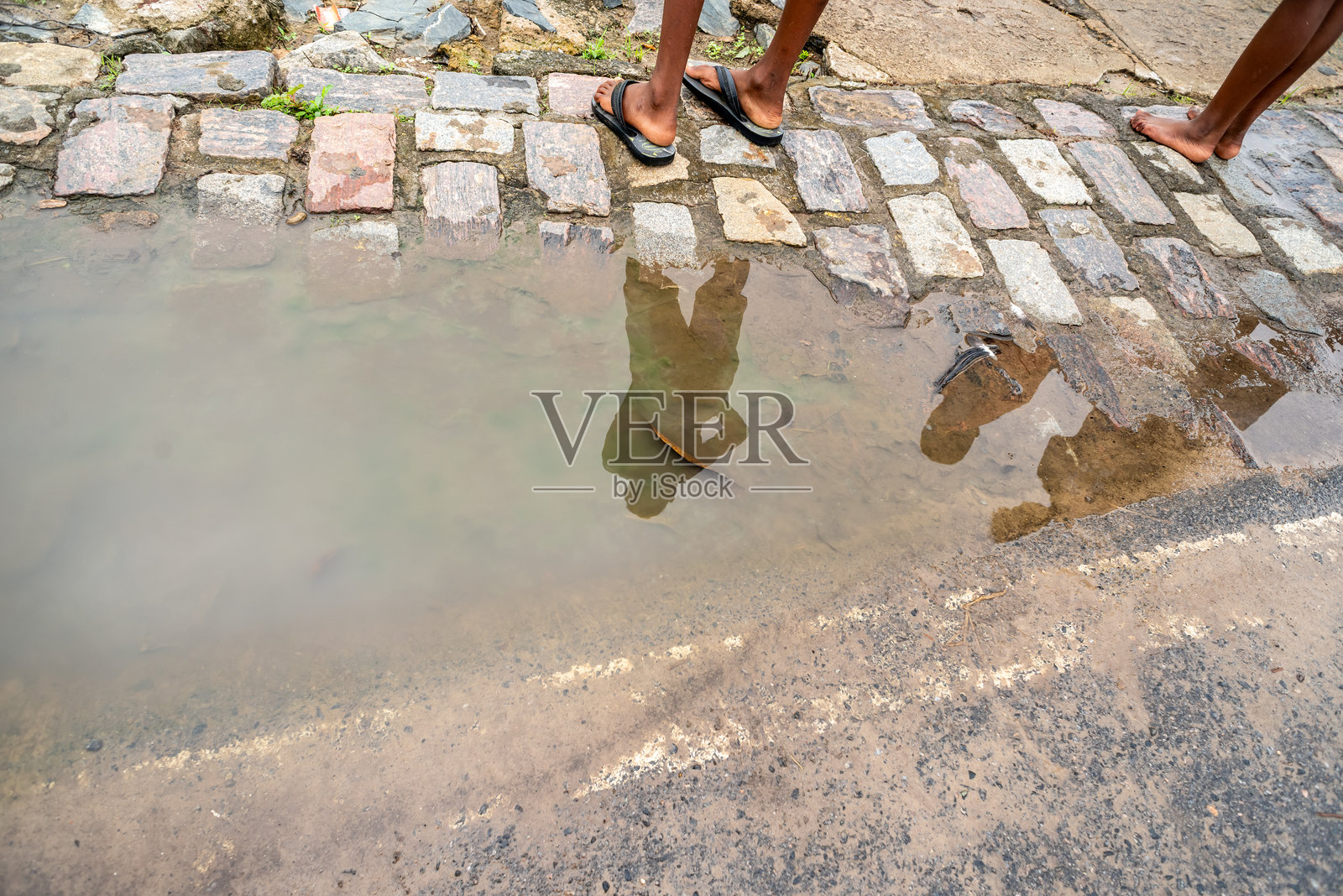 雨天水洼中不明人物的倒影。照片摄影图片