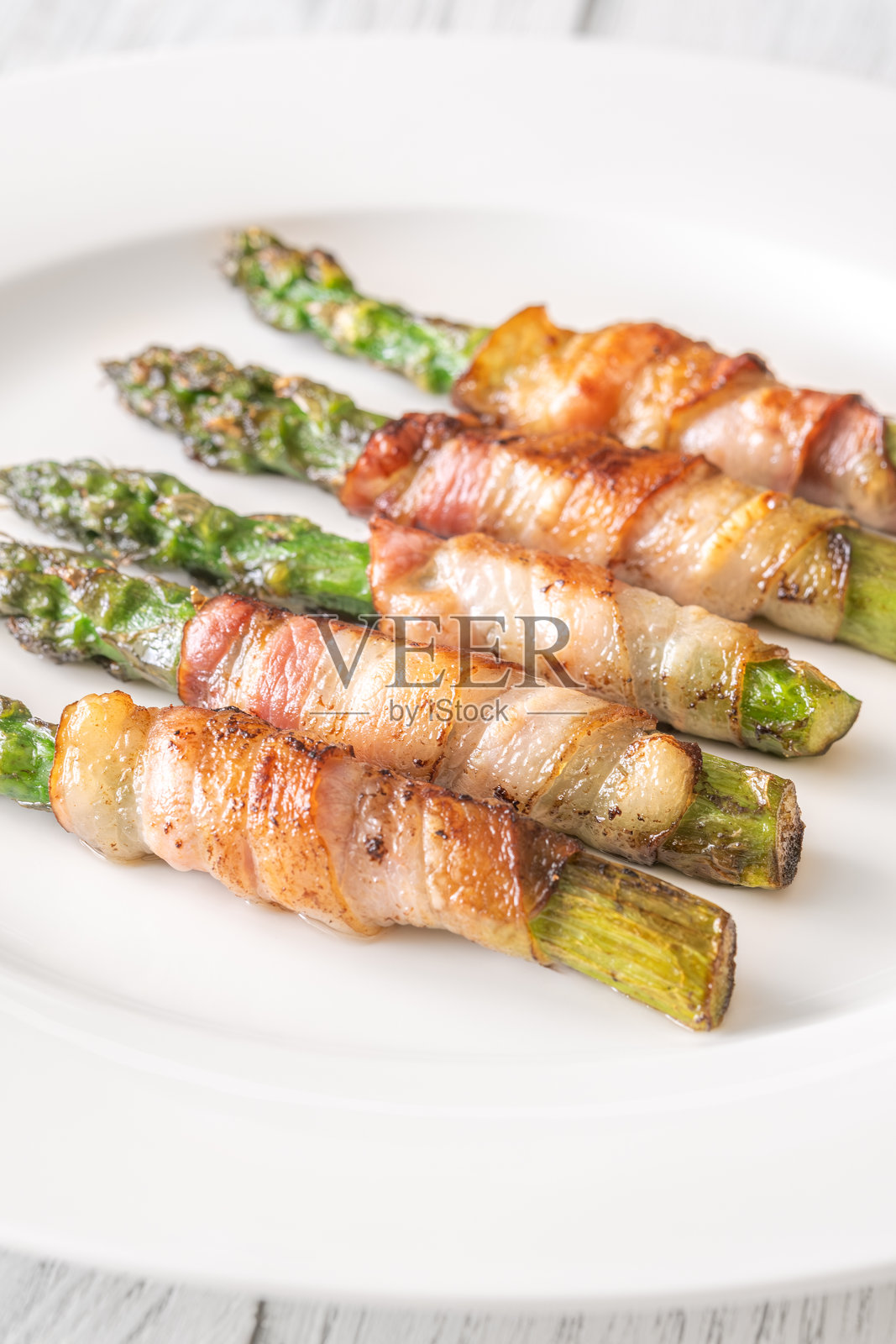 脆皮炸芦笋裹培根，简单地放在白色盘子上照片摄影图片