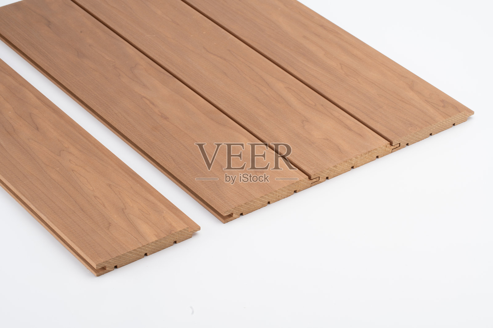 棕色木质墙板，带有细腻的纹理和深邃的沟槽，整齐地排列在白色背景上，适用于室内装饰或声学用途。照片摄影图片
