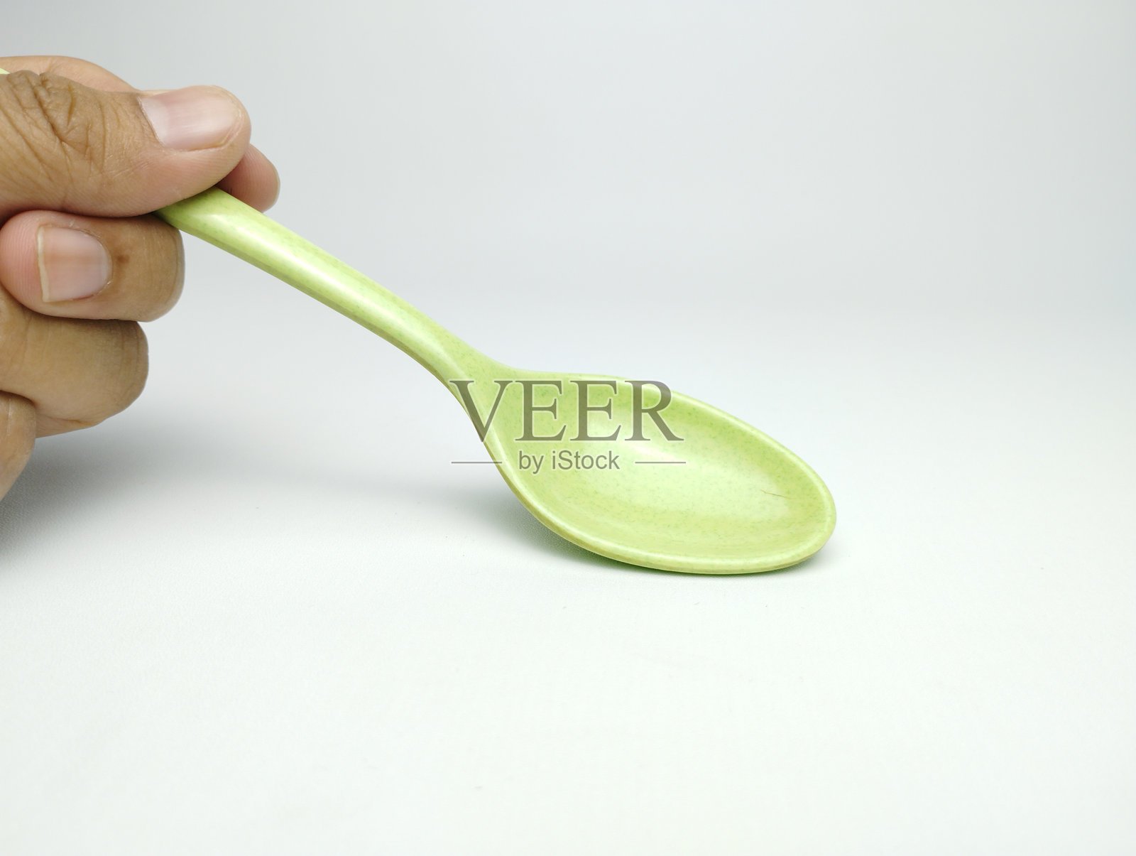 绿色三聚氰胺勺子，背景为白色照片摄影图片