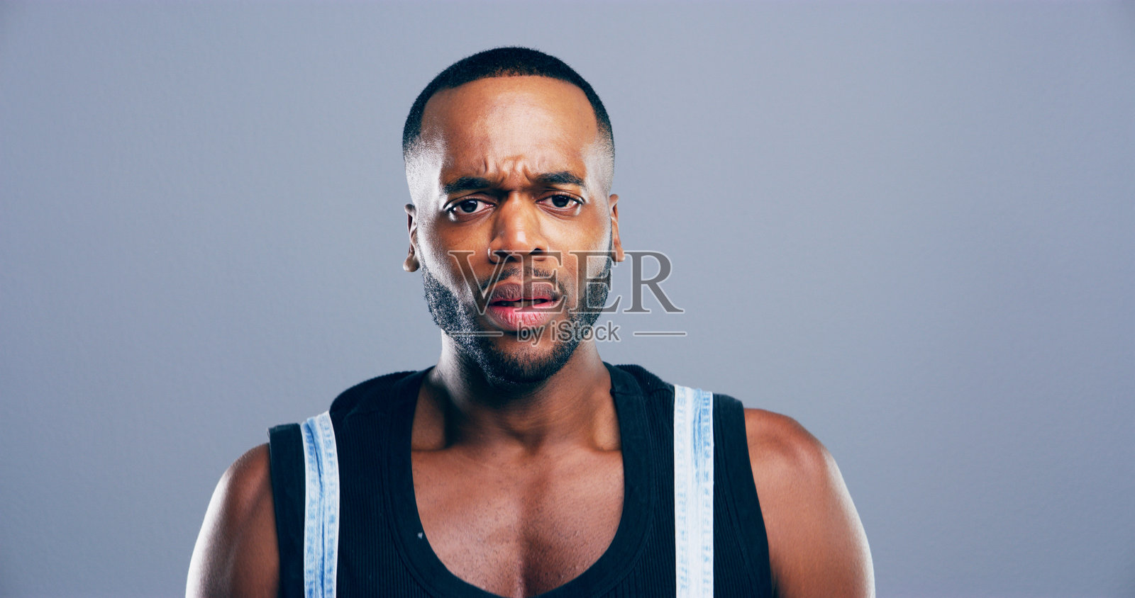 忧虑或悲伤的黑人男性肖像，背景为灰色，表现出关切、担忧或心理健康危机。不快乐的面孔，抑郁或愤怒的男性，因错误而感到沮丧或焦虑。照片摄影图片
