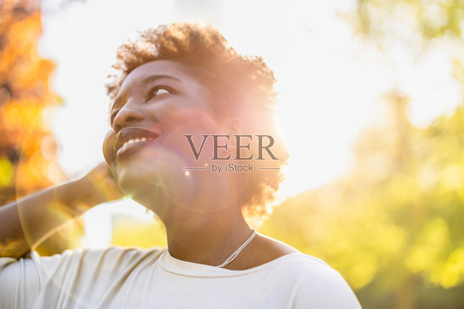 阳光明媚的日子里，公园里微笑的年轻女性肖像照片摄影图片