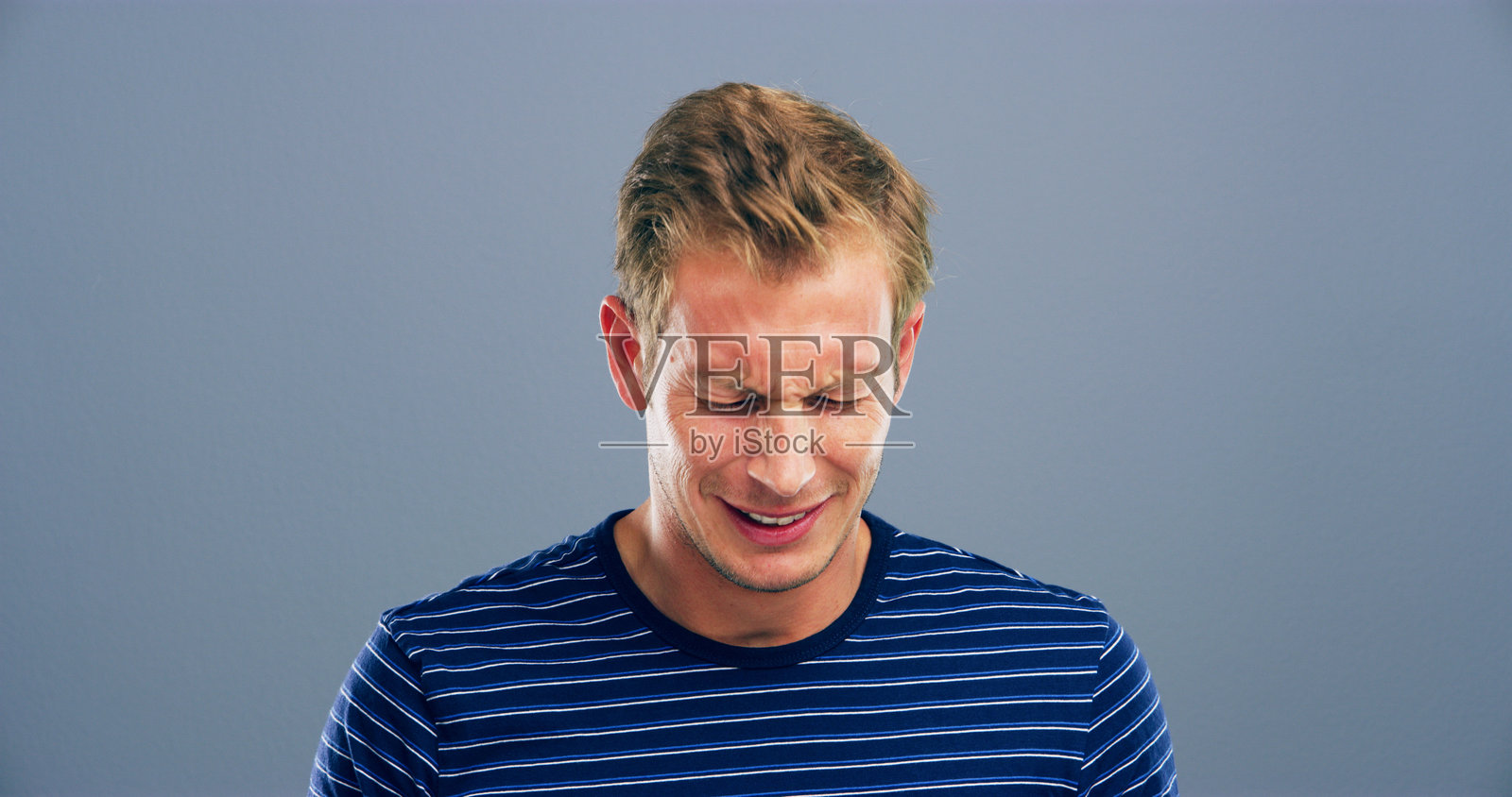 在灰色背景下，哭泣、悲伤的男人面孔，表现出抑郁、心碎和情感。眼泪、哀悼和孤独的人因分手、坏消息和痛苦而感到沮丧和不快乐。照片摄影图片