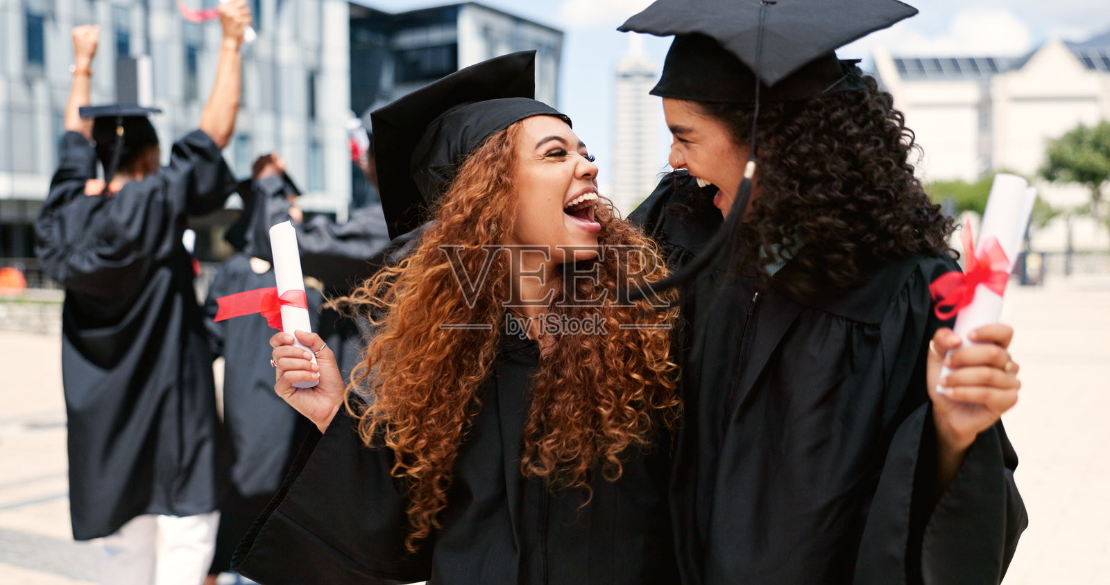 毕业，快乐的女性或学生在大学里拥抱，庆祝教育目标、证书或成功。学校、奖学金或兴奋的毕业生在校园里开玩笑，微笑和大学成就。照片摄影图片