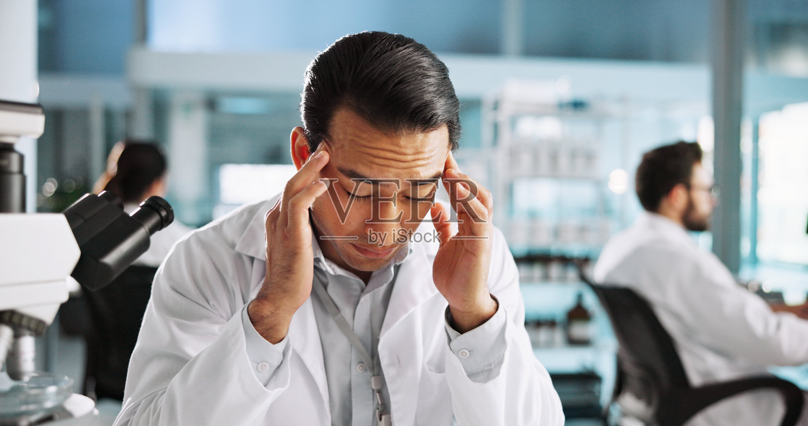 头痛、疲惫与实验室中的男性进行研究失误、临床试验失败或精疲力竭。医疗错误、压力和医疗测试结果与在诊所中因疲劳和危机而感到不适的人。照片摄影图片