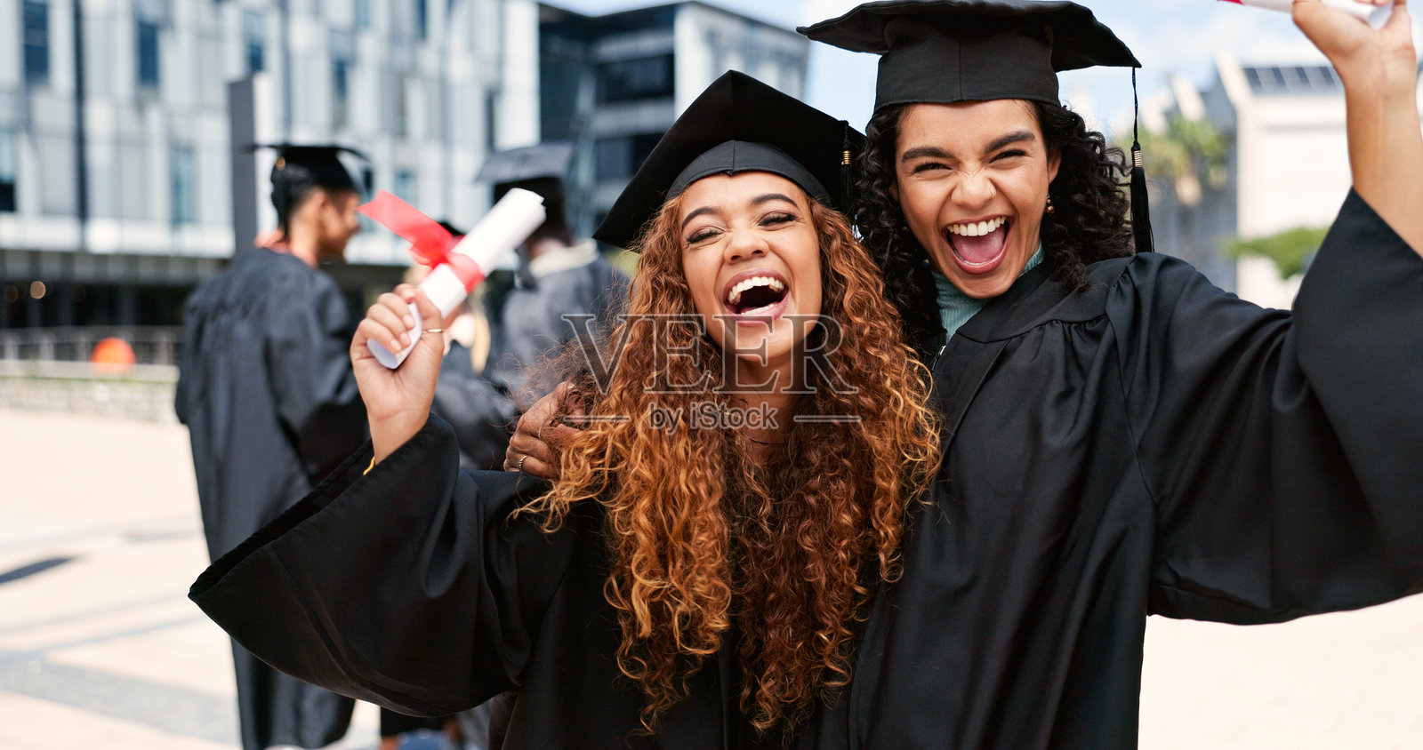 欢笑的快乐女性或学生在毕业时拥抱，庆祝教育目标、学位证书或合影。成功、胜利或兴奋的毕业生在校园中展示奖学金、微笑和大学成就。照片摄影图片