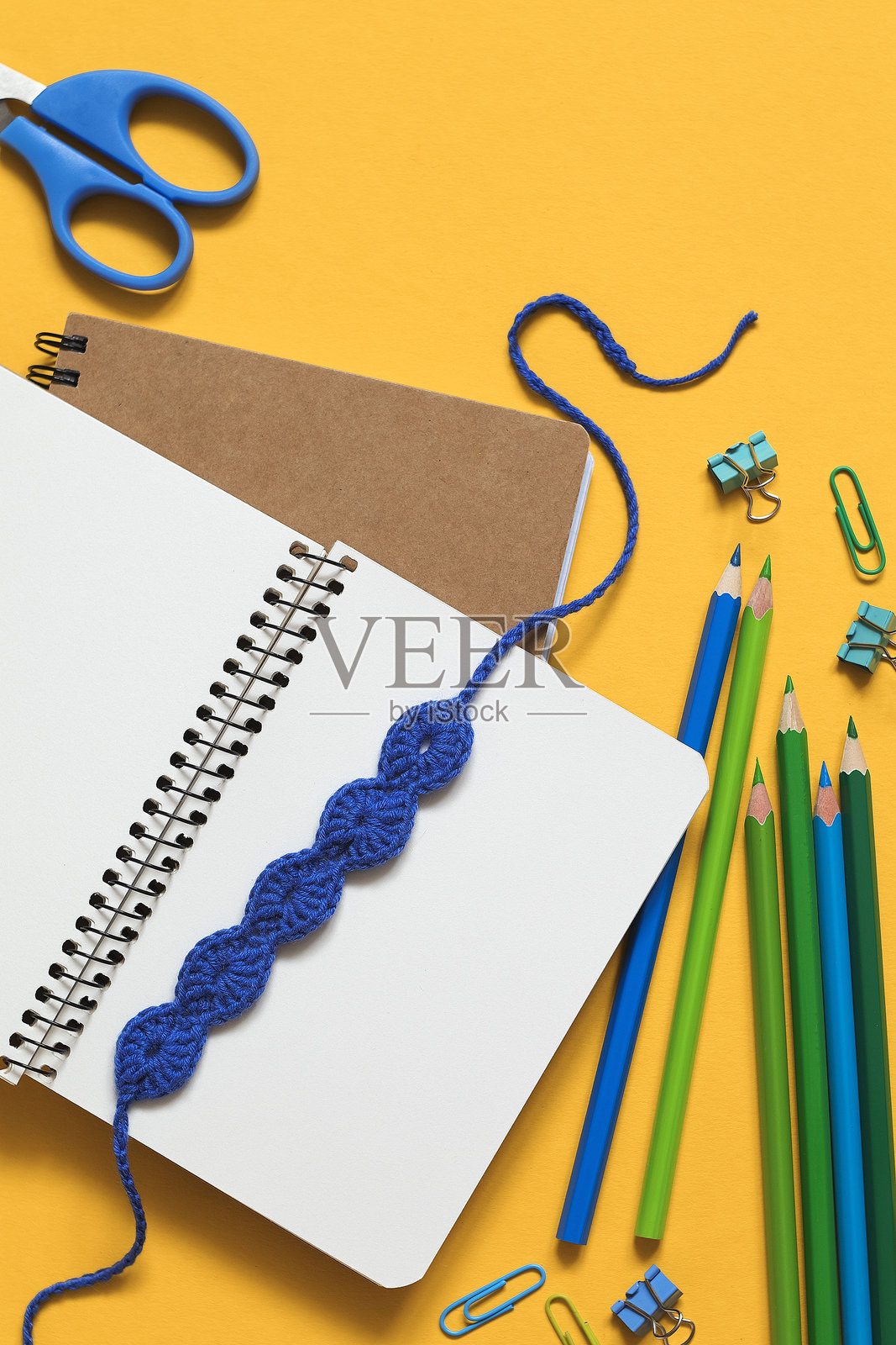 黄色背景上的学校文具与蓝色钩针书签。俯视图。留白空间。照片摄影图片