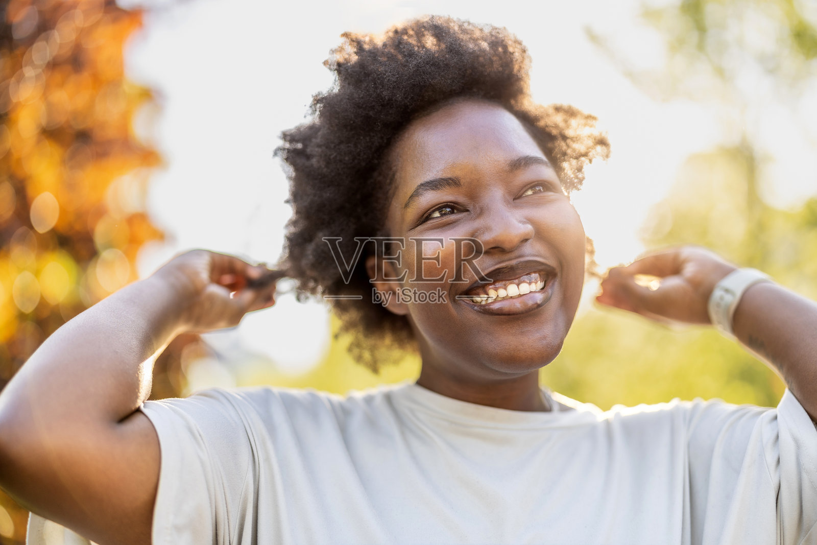 阳光明媚的日子里，公园里微笑的年轻女性肖像照片摄影图片