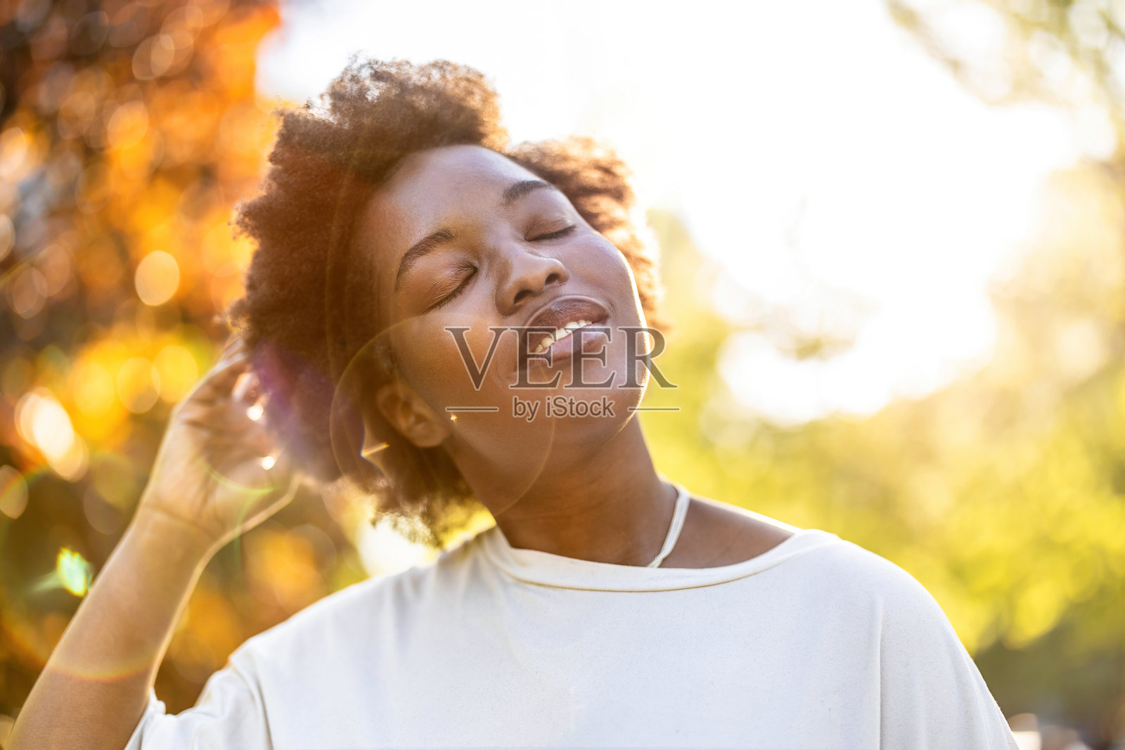 阳光明媚的日子里，公园里微笑的年轻女性肖像照片摄影图片