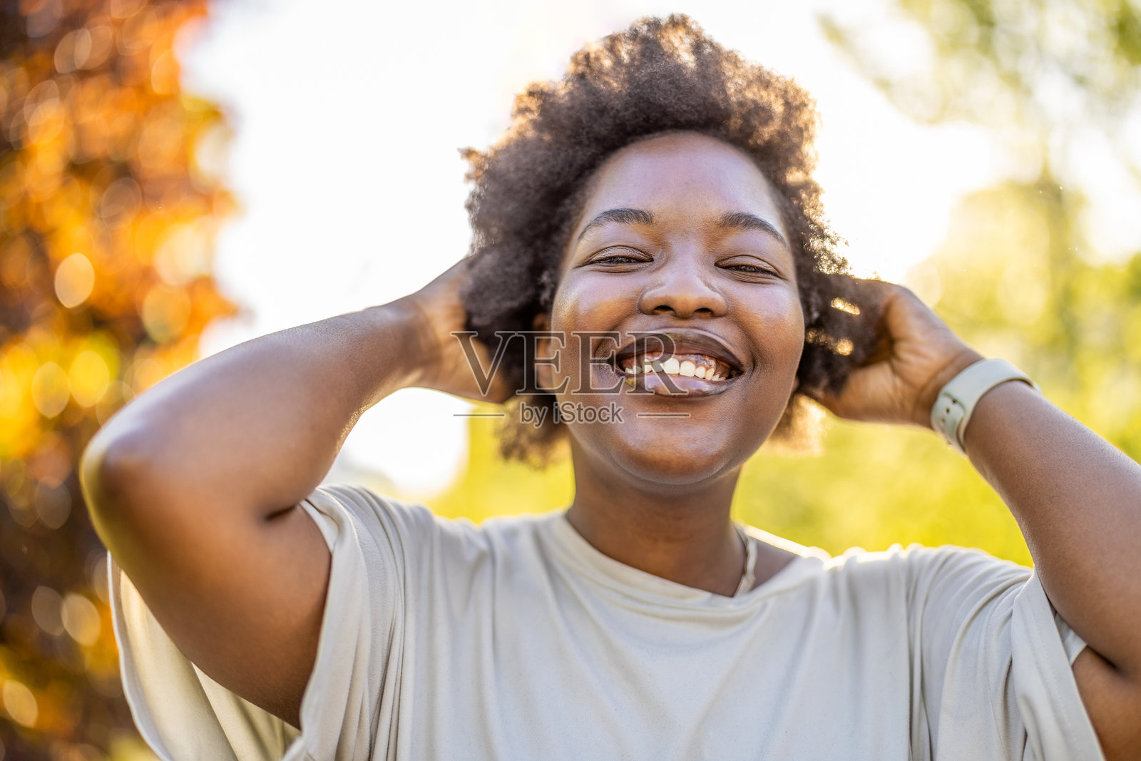 阳光明媚的日子里，公园里微笑的年轻女性肖像照片摄影图片