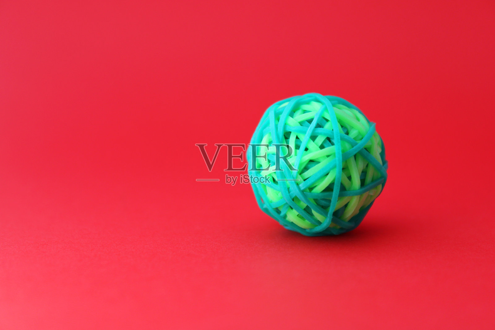 冲突球，由绿色橡皮筋形成的球体照片摄影图片