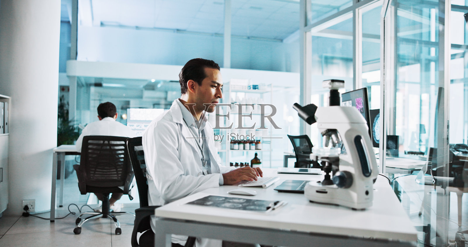 创新、笔记本电脑和科学，实验室中的男性进行医疗、医学或制药研究。计算机、显微镜和在键盘上打字的科学家，参与临床试验以进行开发。照片摄影图片