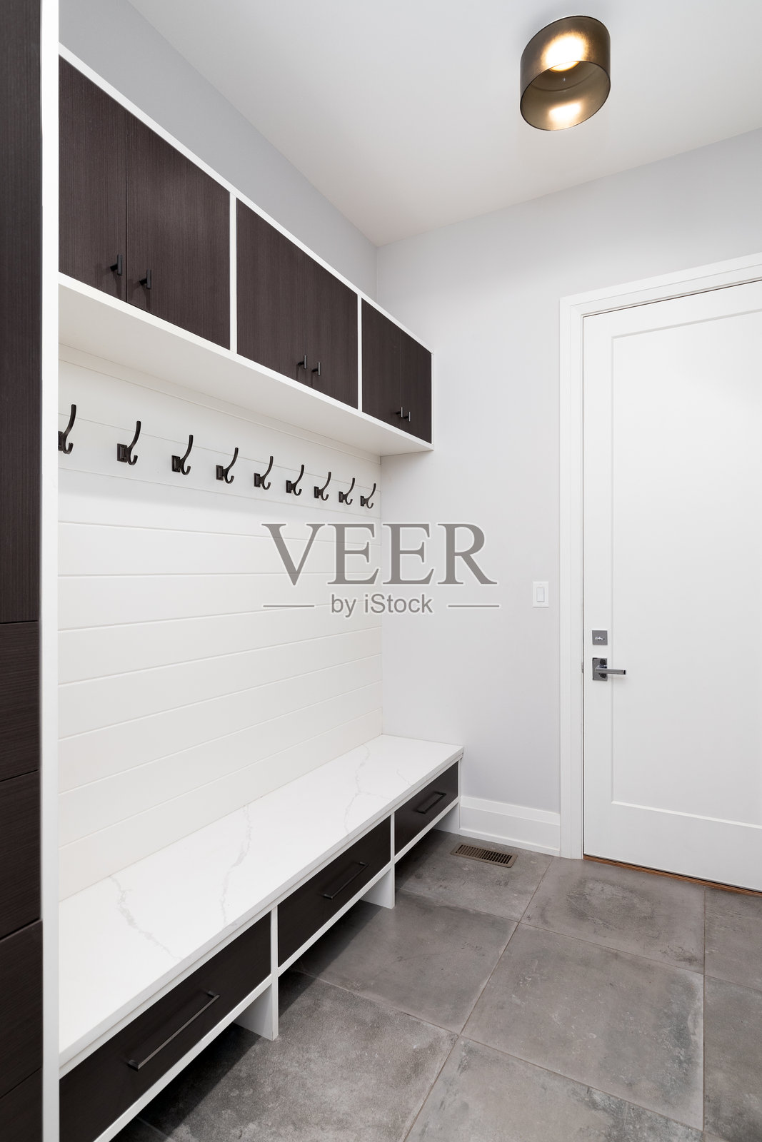 一个带有木制橱柜和白色长椅的门厅。照片摄影图片