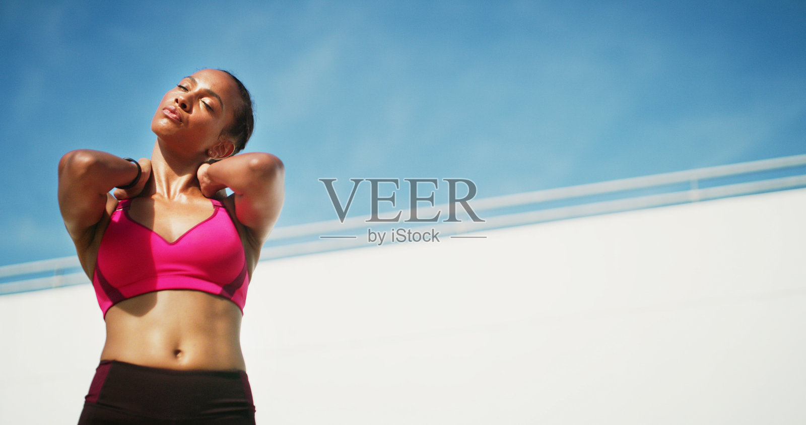 健身，女性颈部拉伸与休息，锻炼空间和汗水与健康。运动员，热身和蓝天背景，适合表现、身体目标和夏季户外运动的低角度拍摄。照片摄影图片