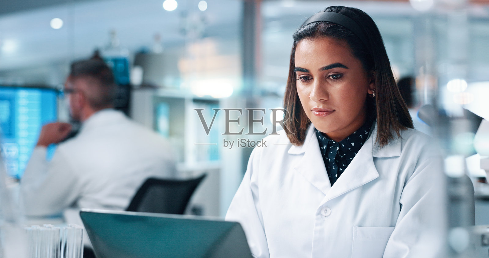 研究人员、科学家和使用笔记本电脑的女性，进行医学实验和互联网医疗。个人、员工和研究人员使用科技，治疗和数字应用，疫苗制造和测试结果。照片摄影图片