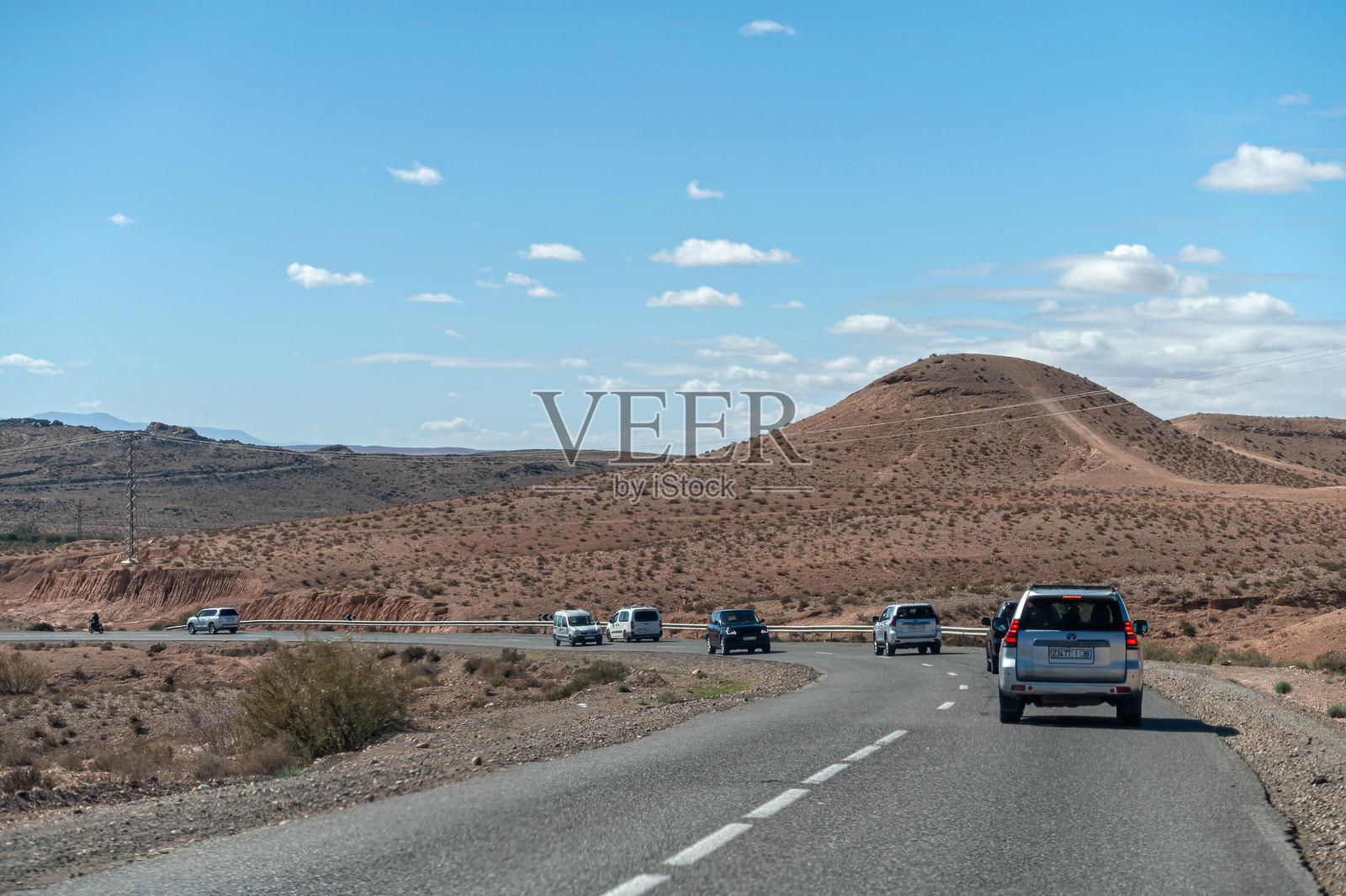 游客在晴朗的日子里驾驶四轮驱动车穿越摩洛哥壮丽的阿特拉斯山脉。照片摄影图片