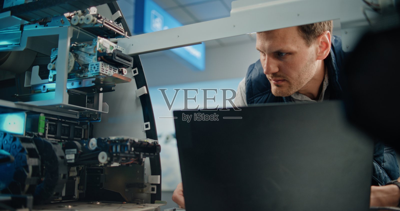 ATM技术员使用笔记本电脑对ATM机进行诊断照片摄影图片