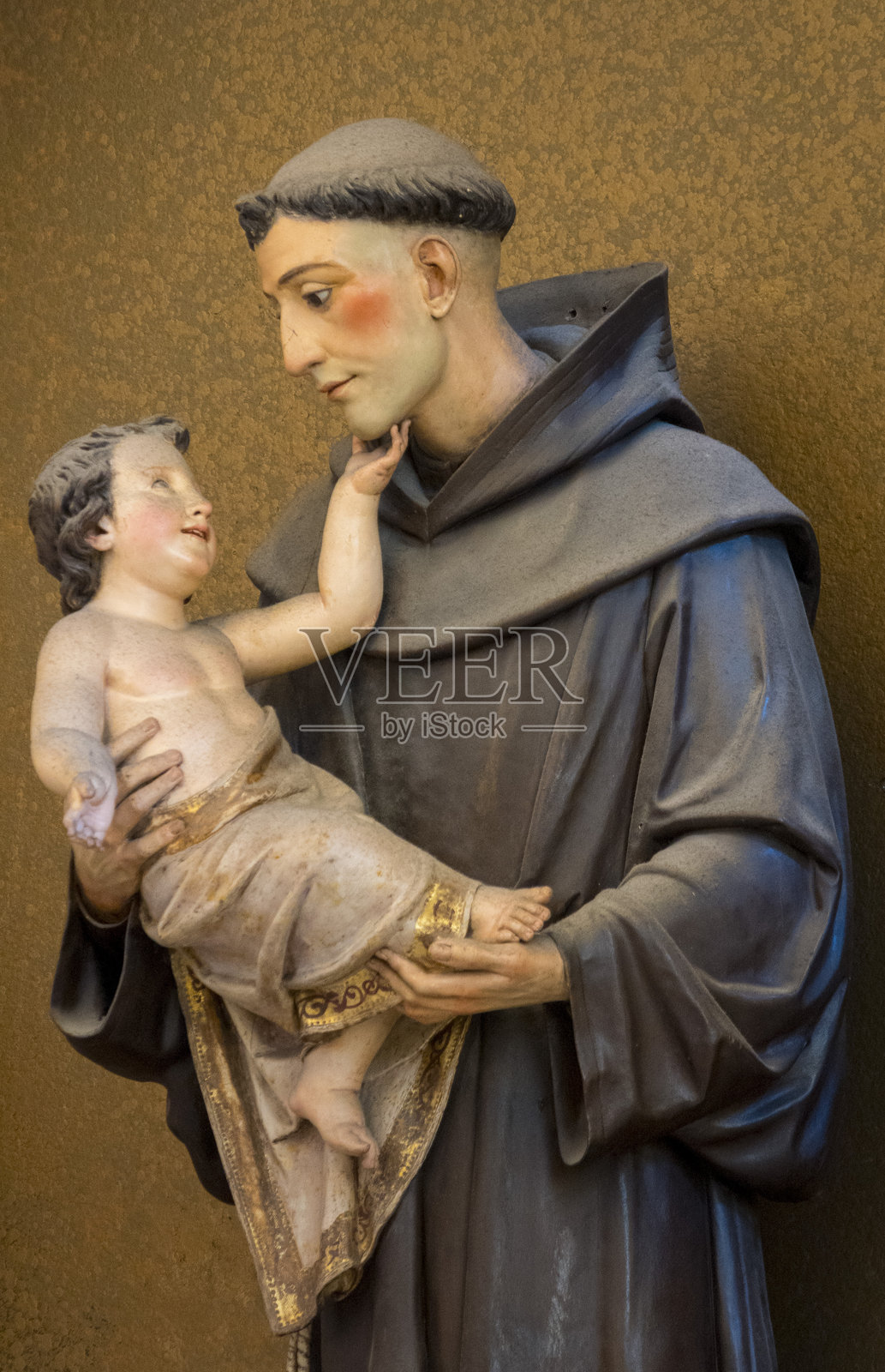 19世纪的圣安东尼雕像,圣安东尼抱着耶稣基督婴儿。照片摄影图片