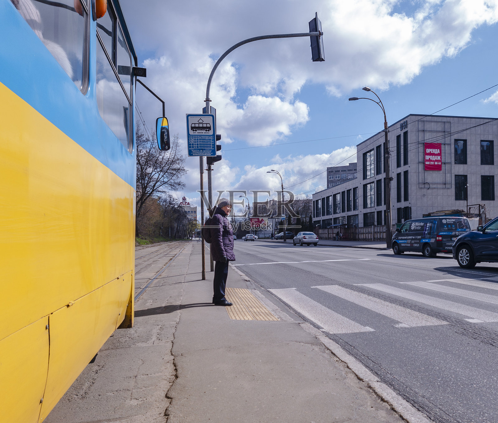 在2025年5月13日，乌克兰基辅的阳光明媚的日子里，居民们在等待公共交通，展现了这座城市充满活力的氛围和城市出行的景象。照片摄影图片