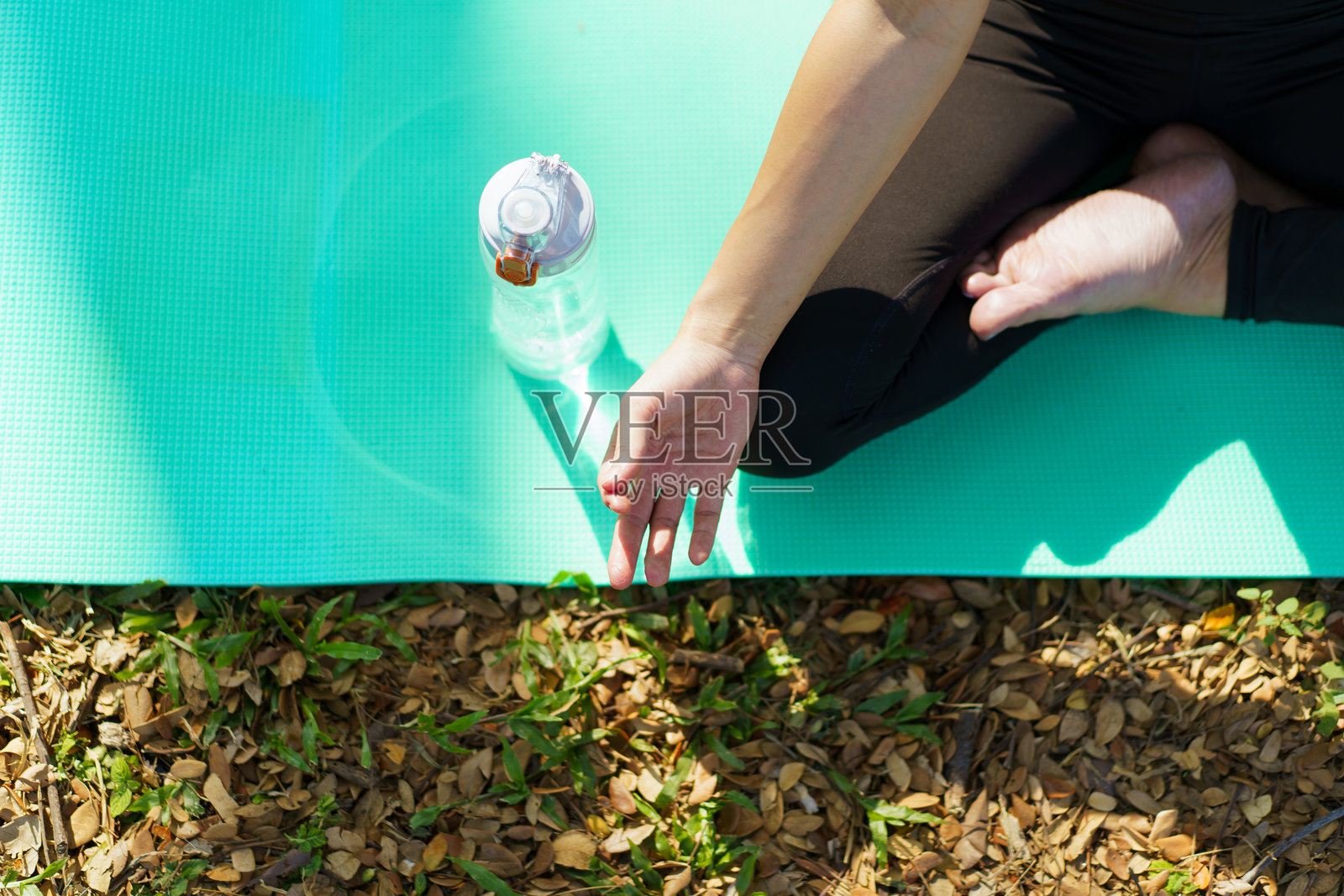 亚洲女性在公园的大树下练习瑜伽和冥想，享受宁静的早晨。照片摄影图片