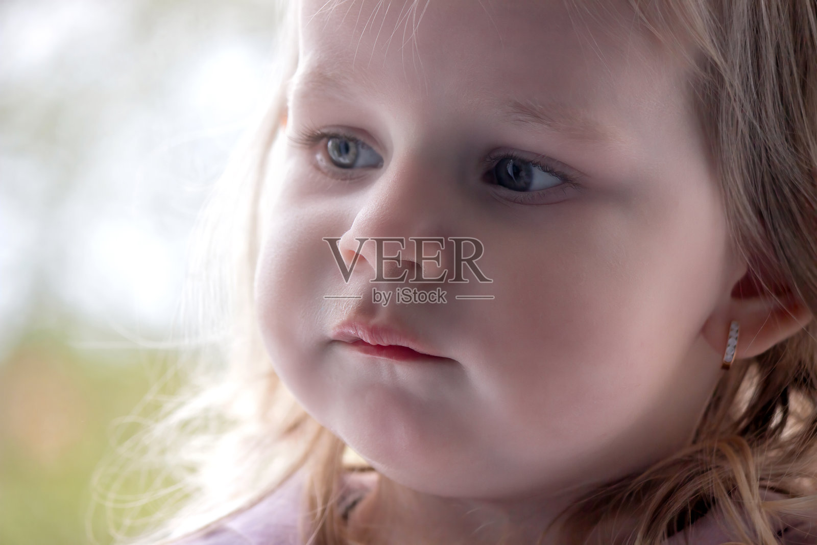 小孩脸部特写，鼻子上有鼻涕。儿童感冒、流鼻涕，过敏。照片摄影图片