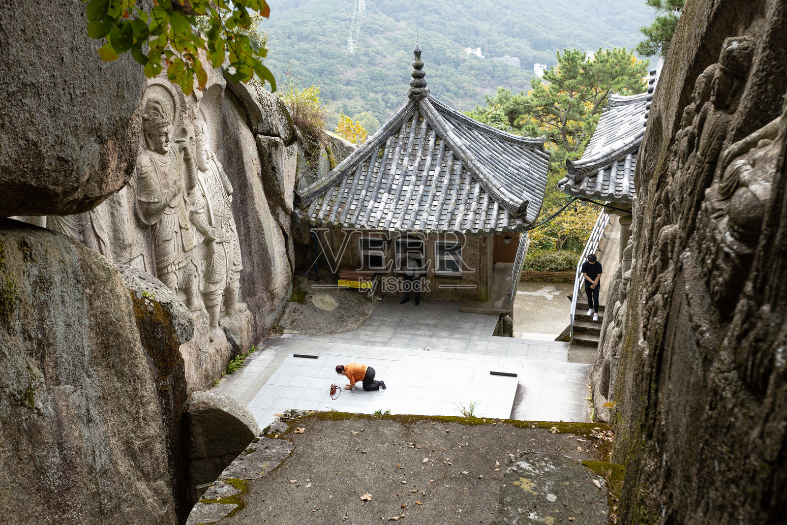 在韩国釜山的石佛寺山庙祈祷的女性照片摄影图片
