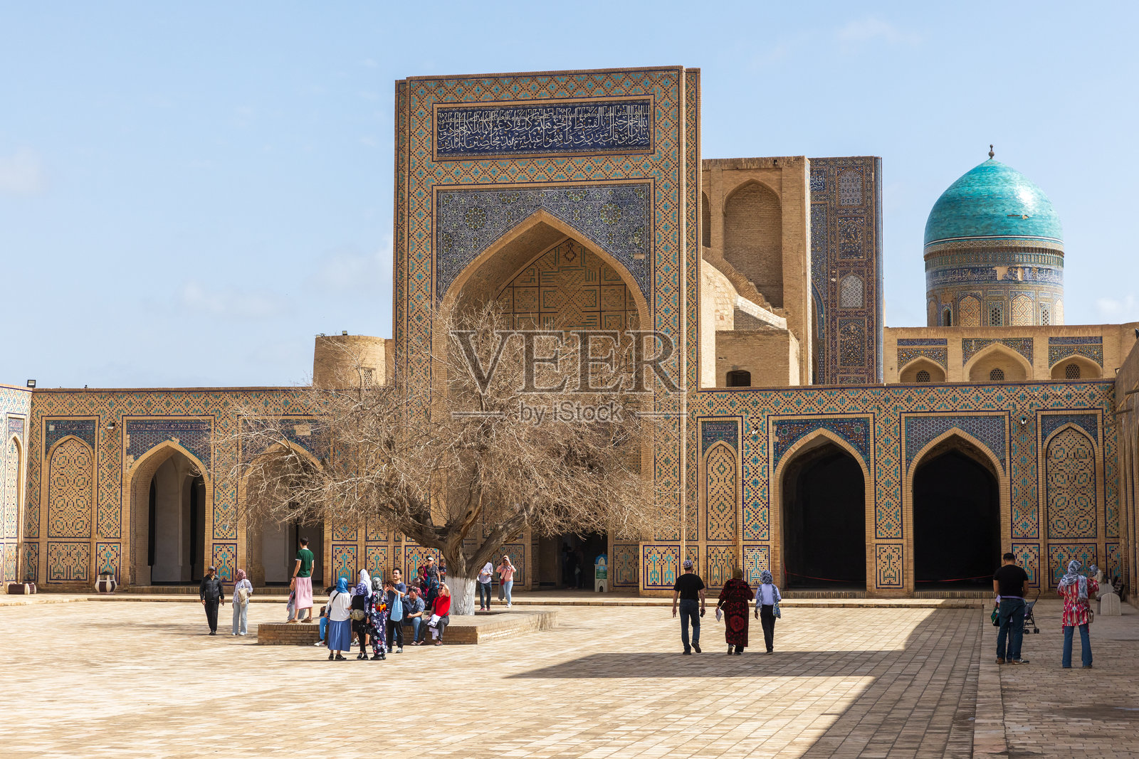 游客们在乌兹别克斯坦布哈拉的卡里扬清真寺内 courtyard。照片摄影图片