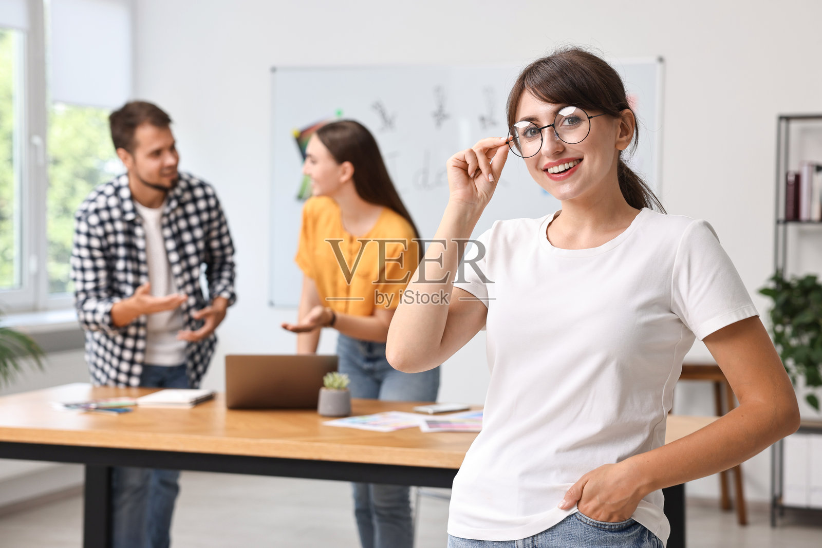 戴眼镜的快乐年轻设计师在办公室里照片摄影图片