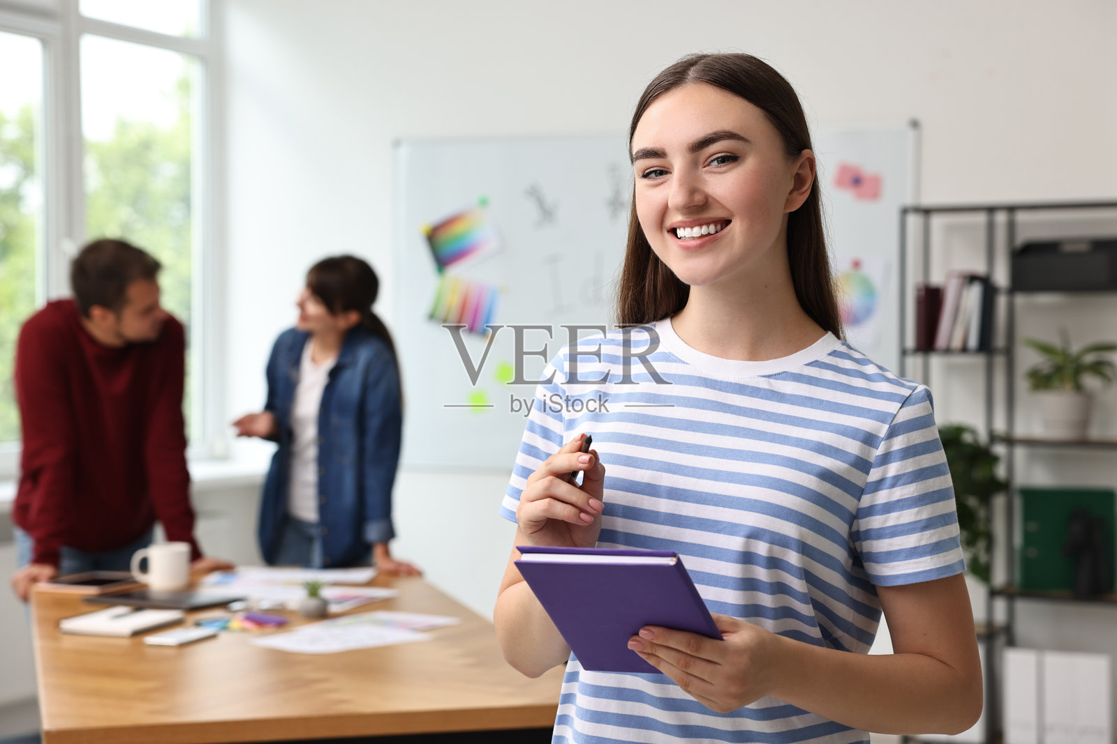 年轻设计师在办公室里开心地拿着笔记本的肖像照片摄影图片