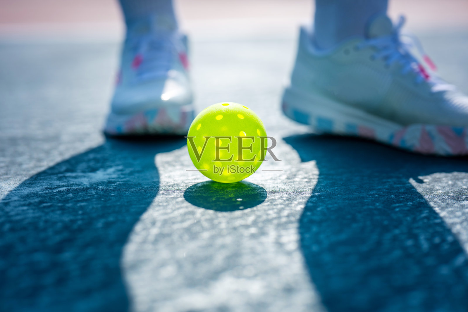 阳光照耀下，腌黄瓜球静静地躺在球场上，投下阴影的低角度拍摄。照片摄影图片