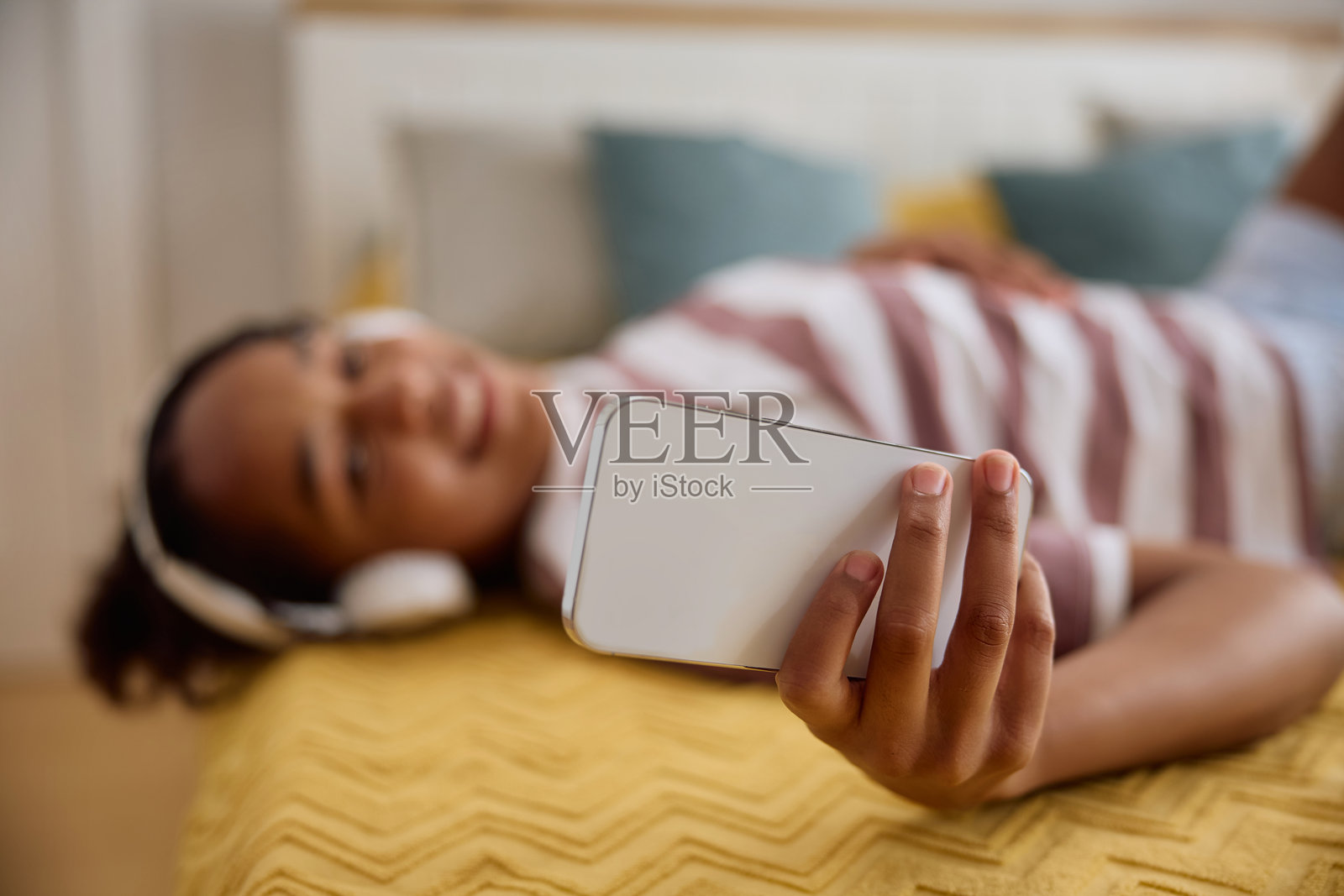 非洲裔美国女孩在家中使用手机的特写镜头。照片摄影图片