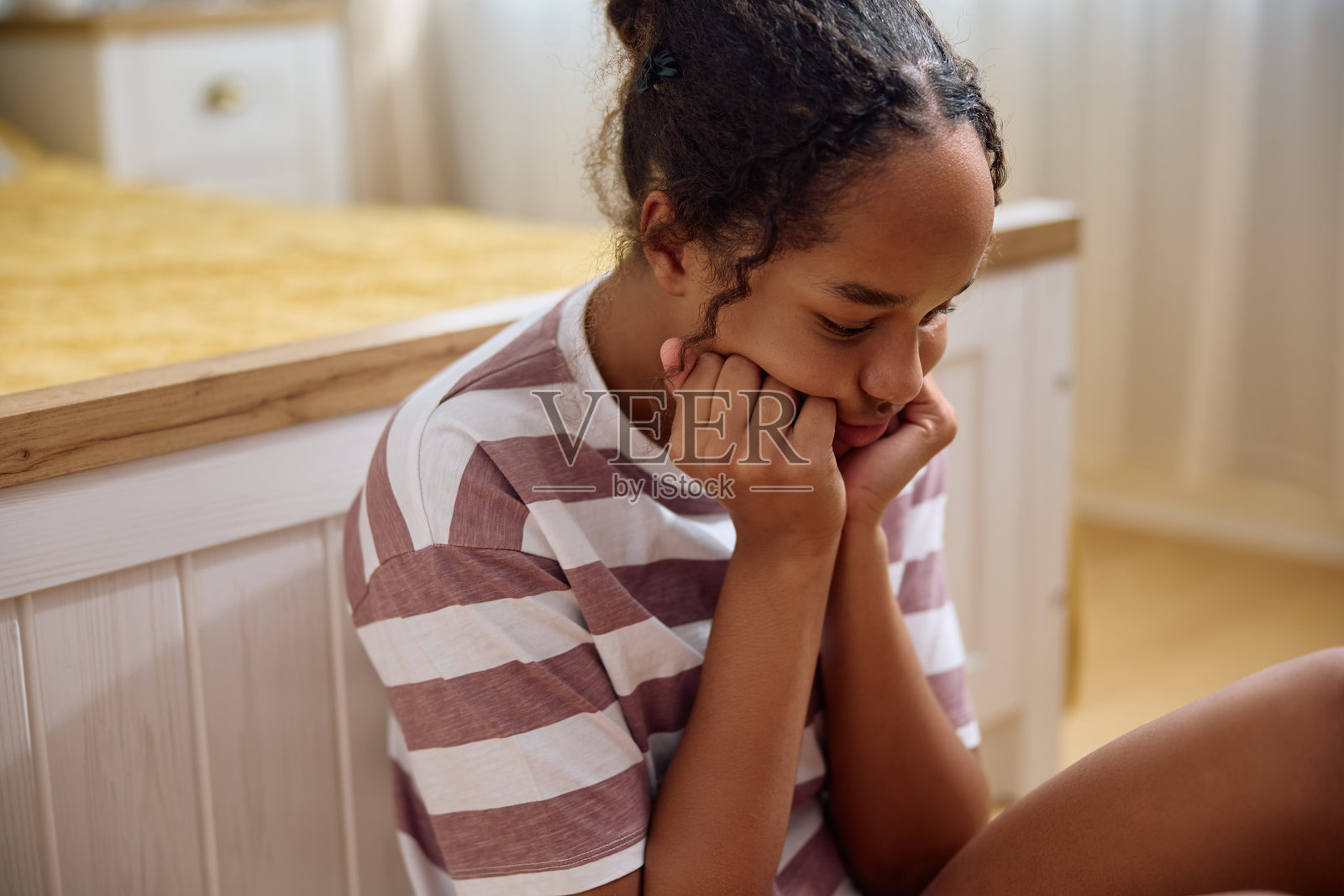 忧郁的黑人少女思考着她在家中的问题。照片摄影图片