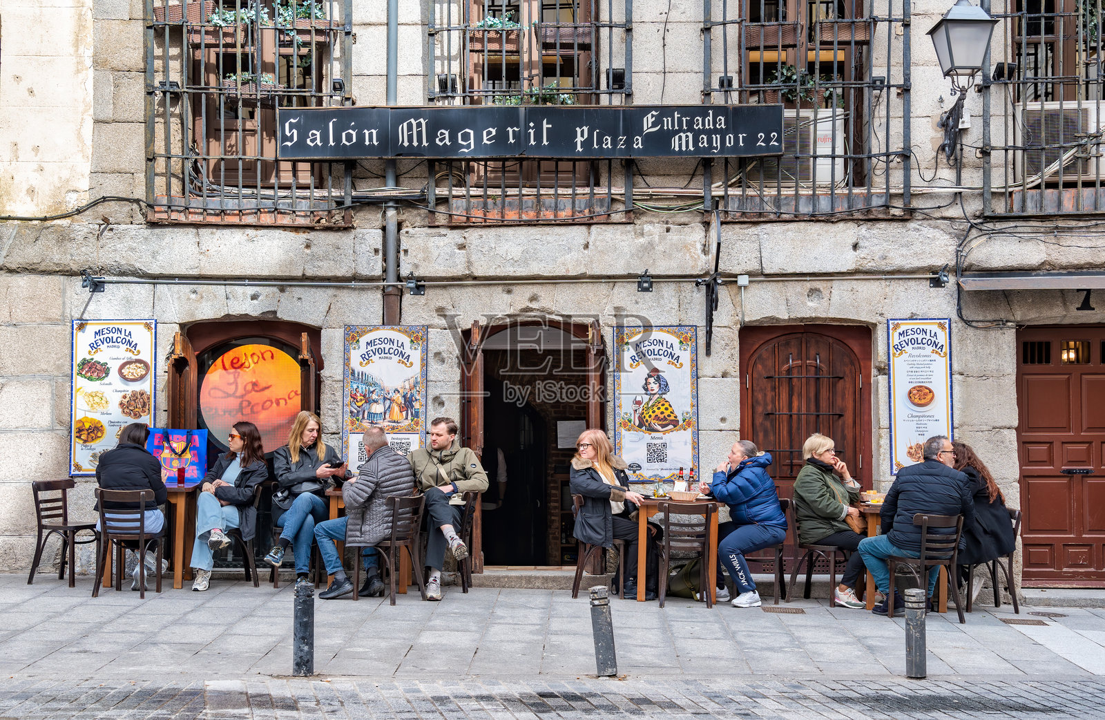 人们在圣米格尔市场附近的户外餐厅露台上享受美食和饮品。照片摄影图片