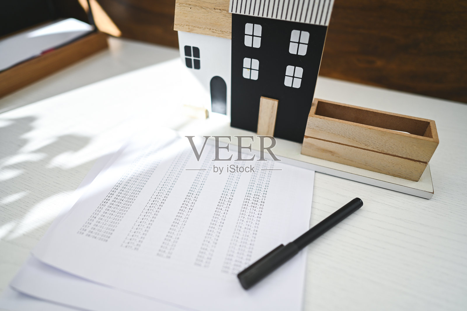 会计师在迷你房屋旁使用电子表格和计算器计算住房贷款照片摄影图片