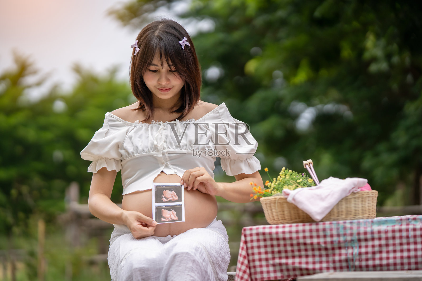 快乐的亚洲孕妇在前院放松照片摄影图片