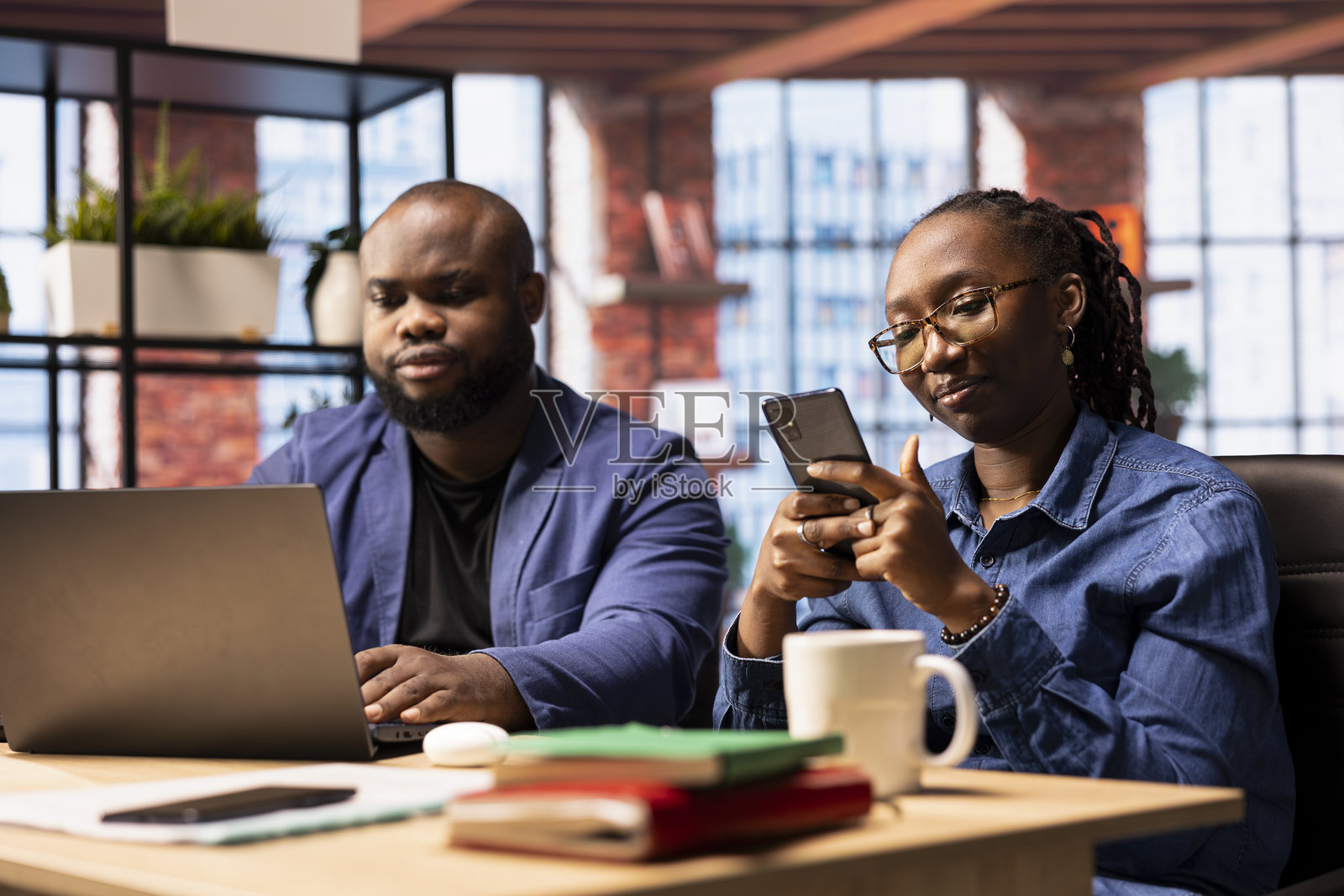 一对非裔美国男女在时尚的阁楼中远程工作照片摄影图片