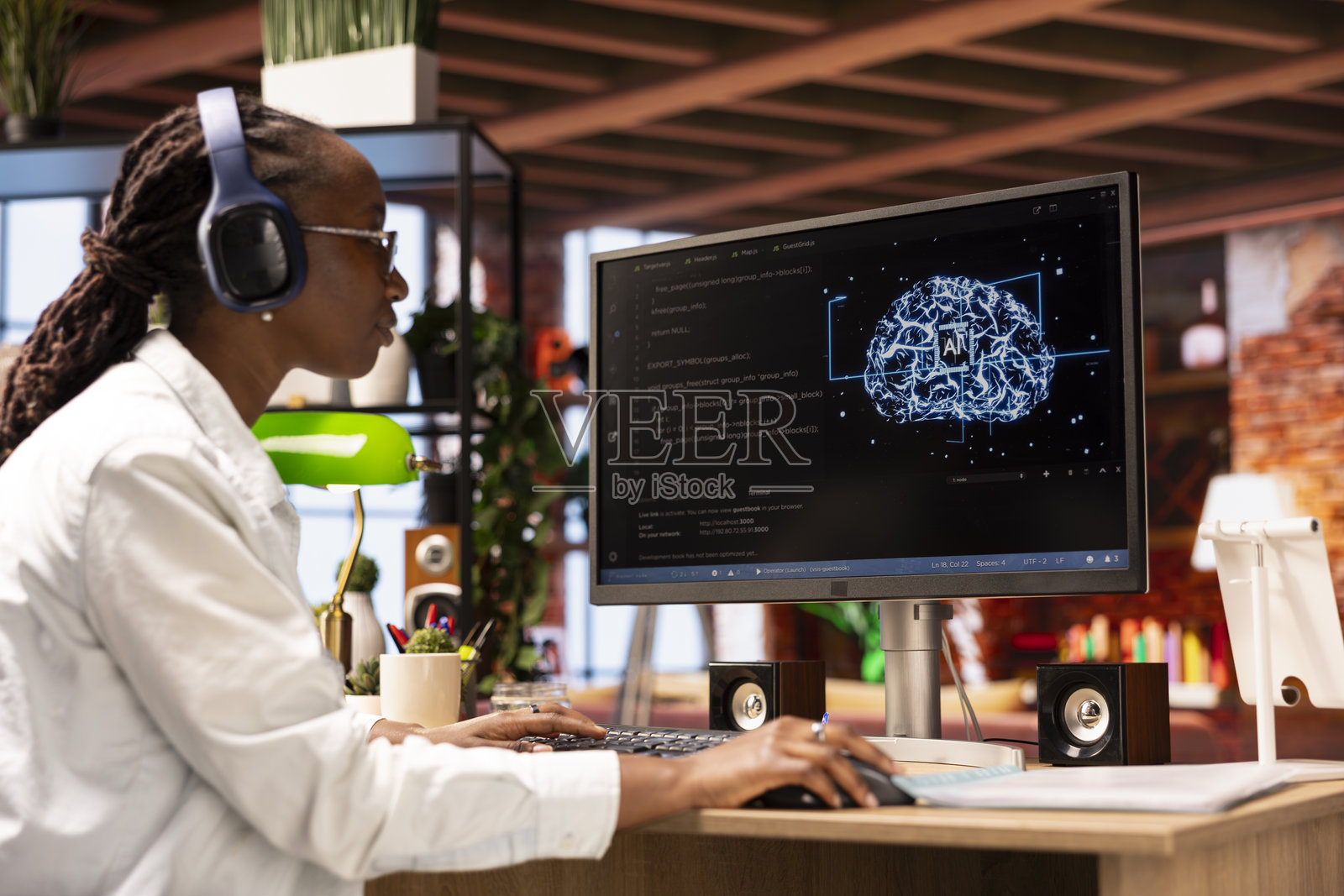 在家工作的员工使用桌面电脑进行人工智能神经网络研究，同时听音乐照片摄影图片