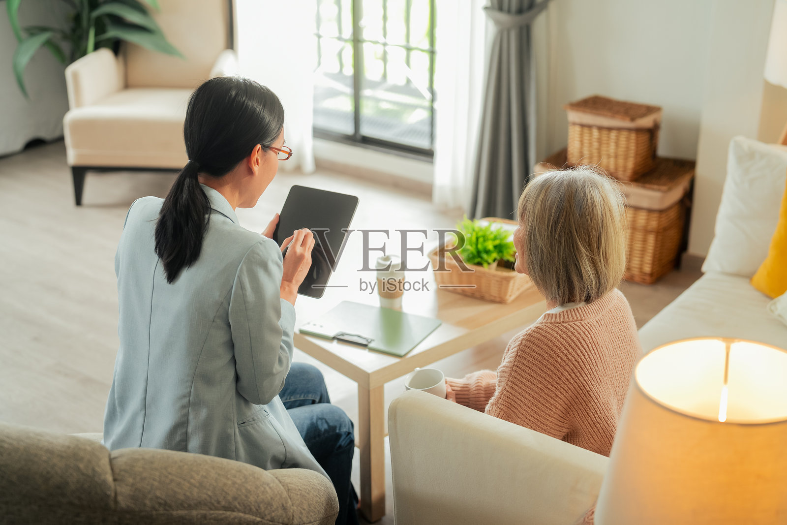 亚洲退休老人与财务顾问交谈，真实场景中的亚洲老年夫妇希望在家中讨论退休计划管理。照片摄影图片