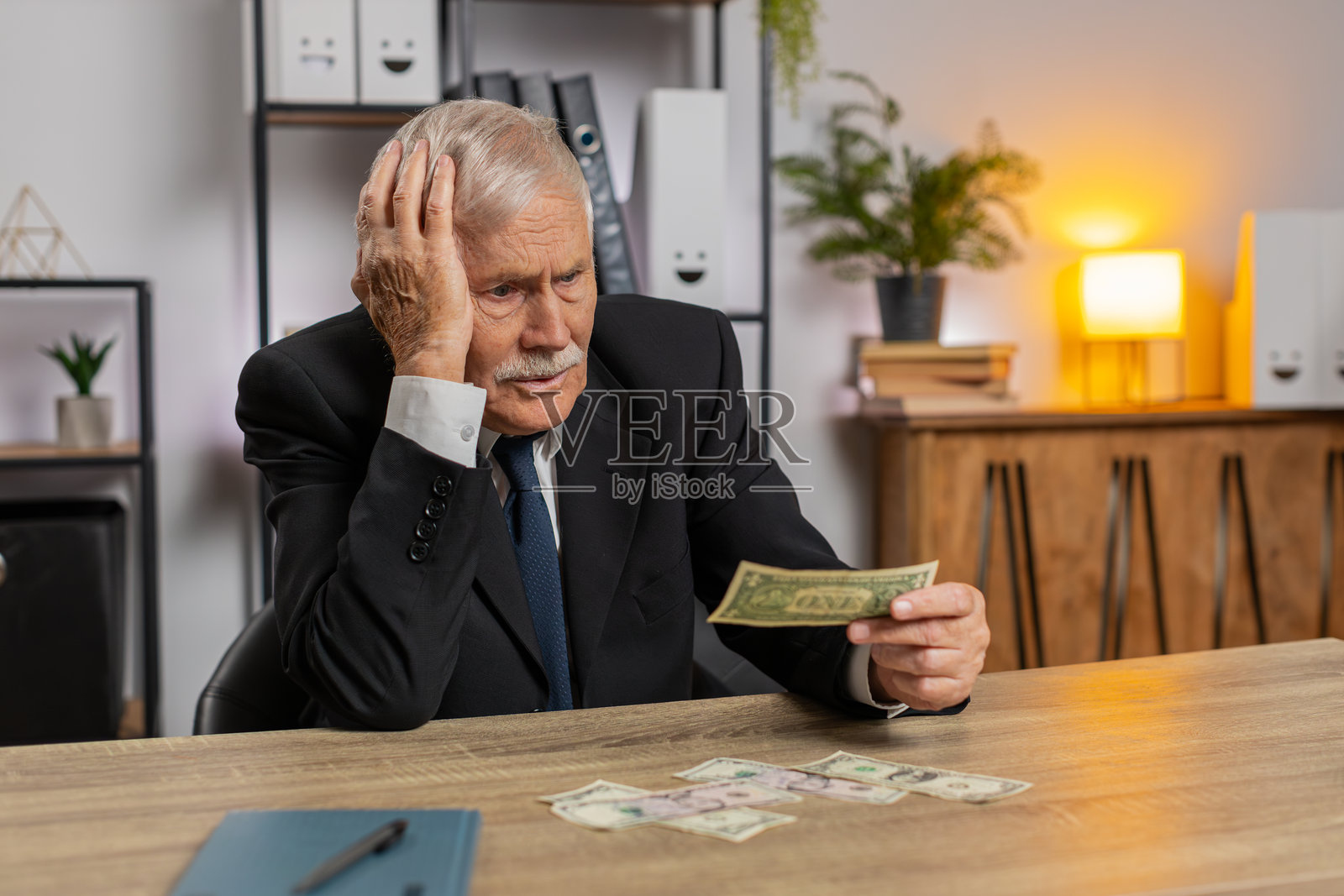 白人老年商人在家中穿着西装数现金，金额不足。照片摄影图片