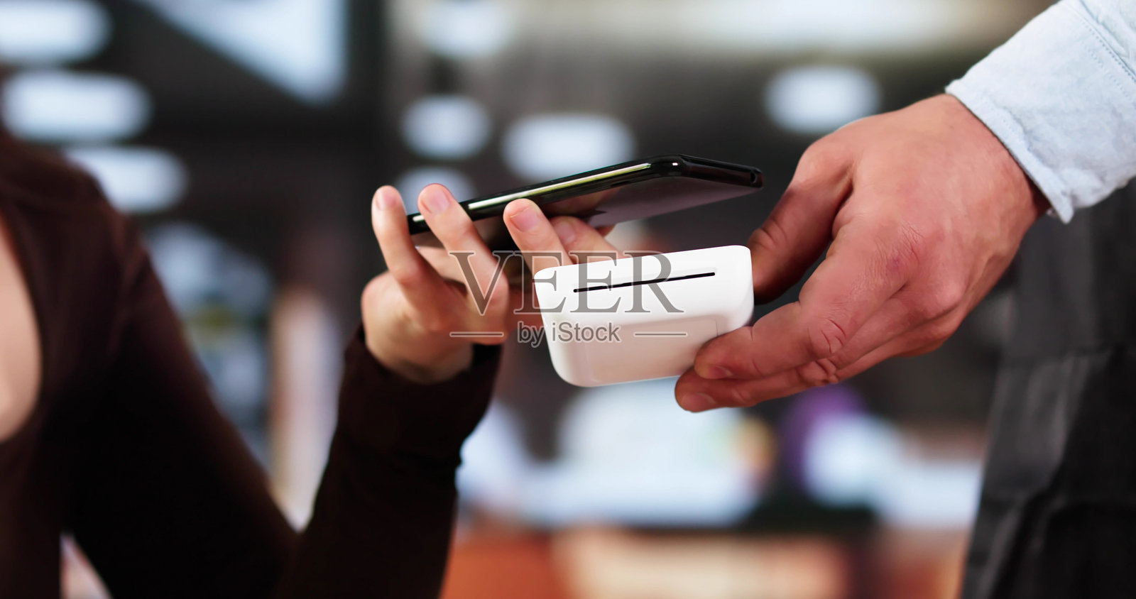 女性在咖啡店结账时使用智能手表进行非接触式支付照片摄影图片