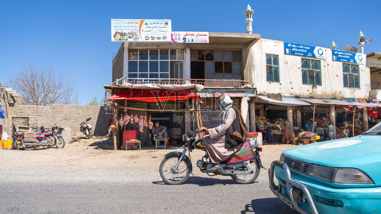 一名阿富汗男子骑着摩托车在阿富汗赫拉特-坎大哈公路上。照片摄影图片