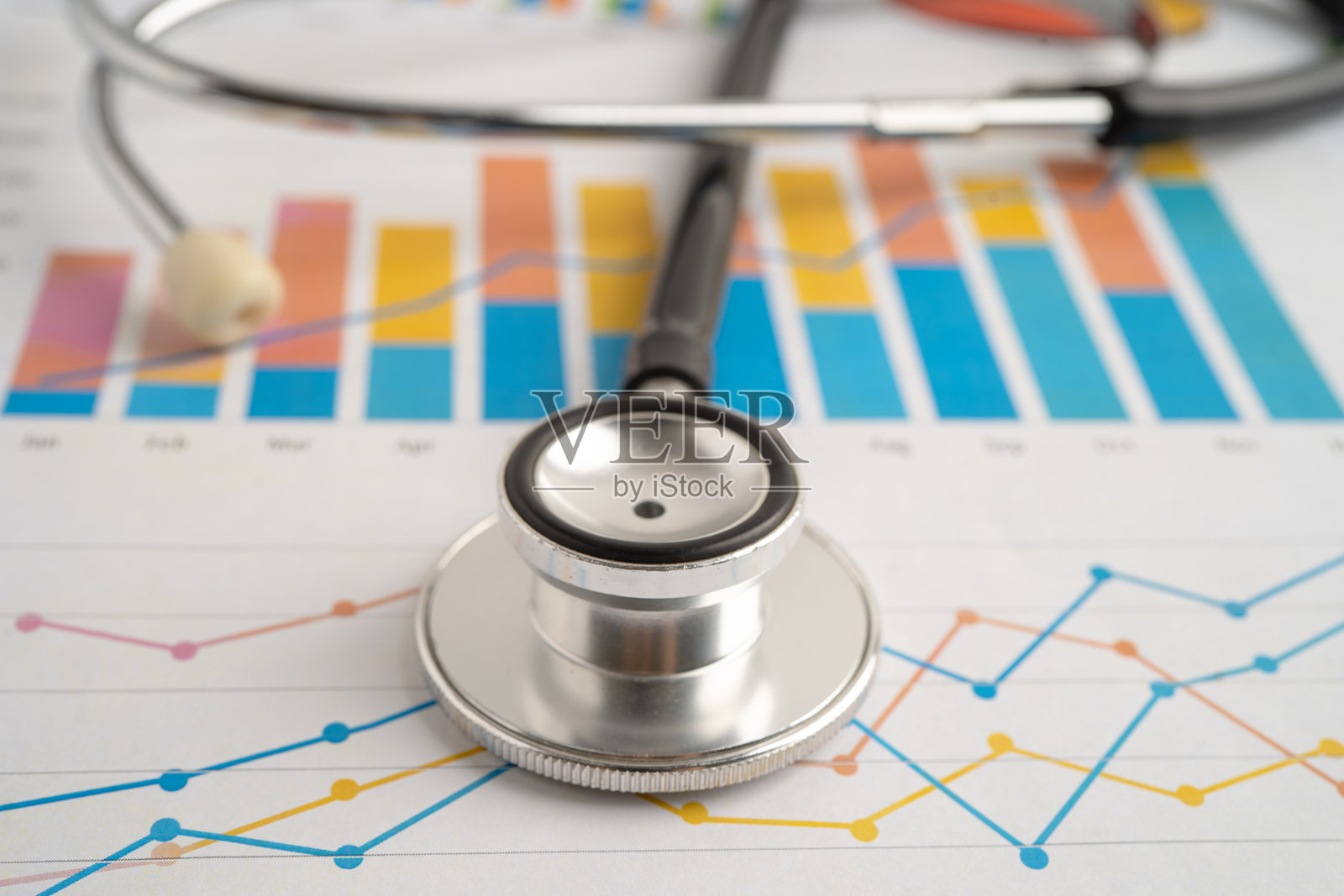 听诊器放在电子表格和图表纸上。照片摄影图片