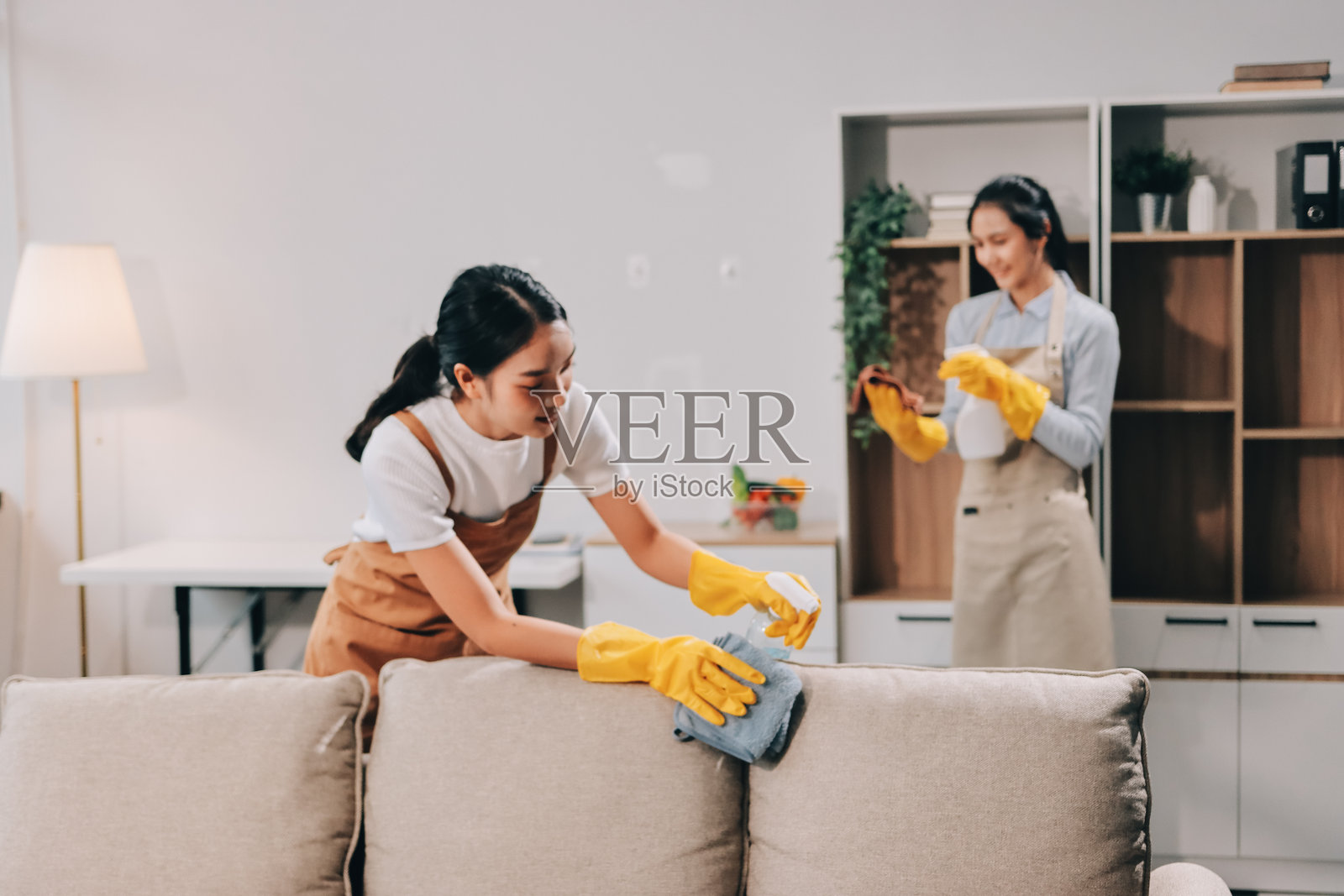 女性清洁工在房间里使用吸尘器照片摄影图片