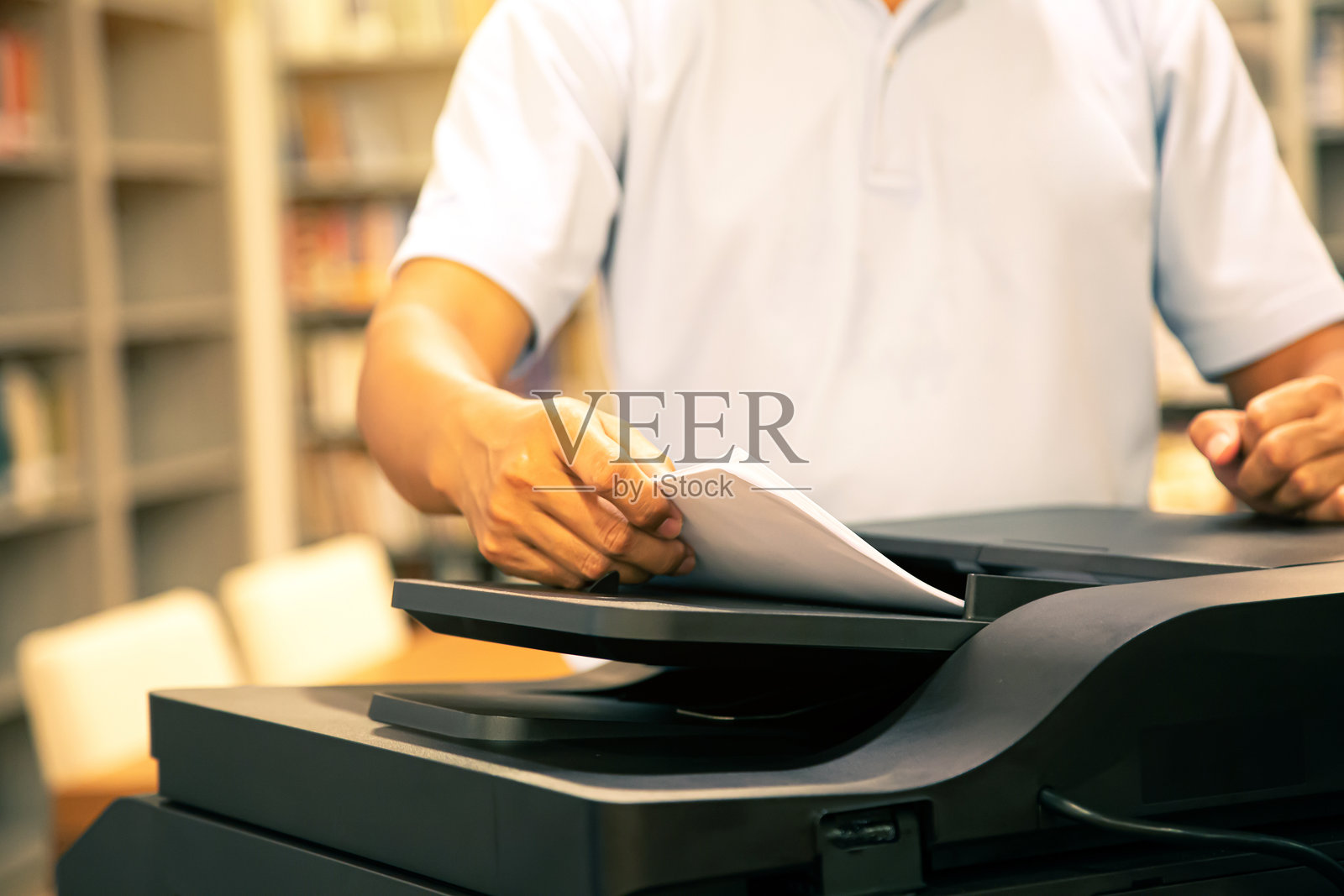 复印机，办公人员的手特写，将纸放在面板上以使用复印机或复印设备进行文档扫描和打印。照片摄影图片