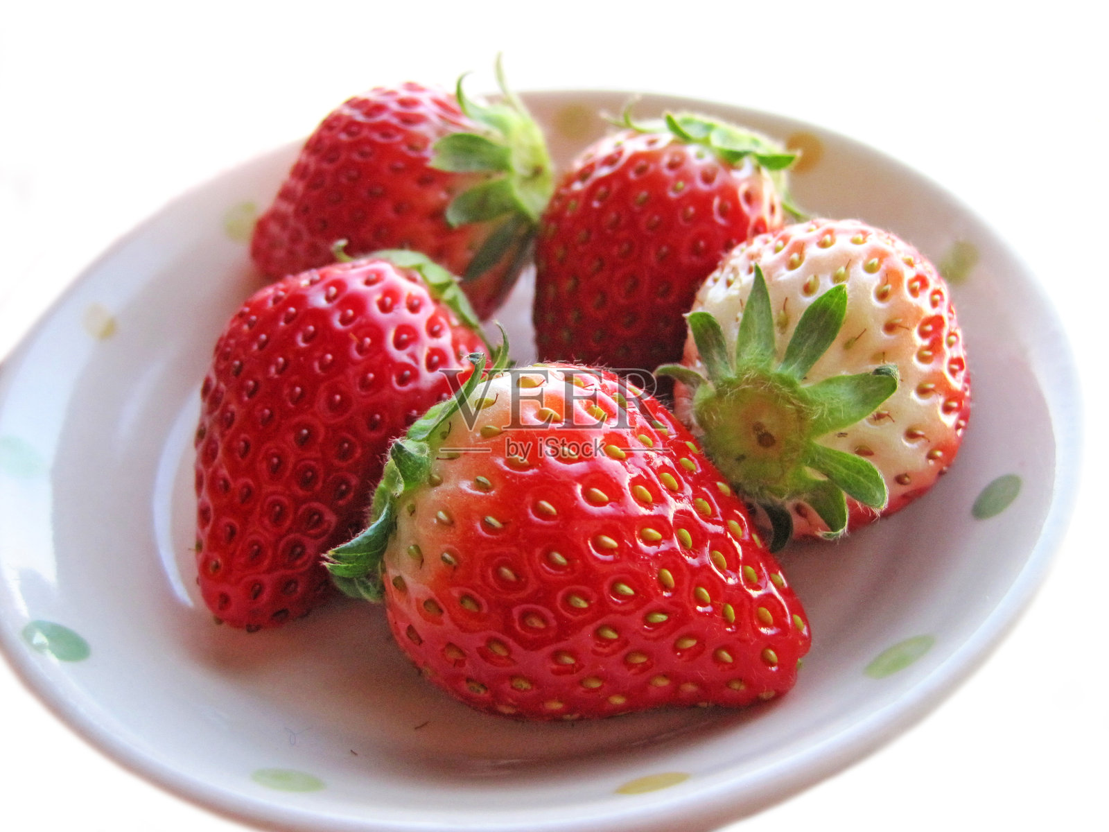 多颗丰硕的草莓放在白色盘子上照片摄影图片