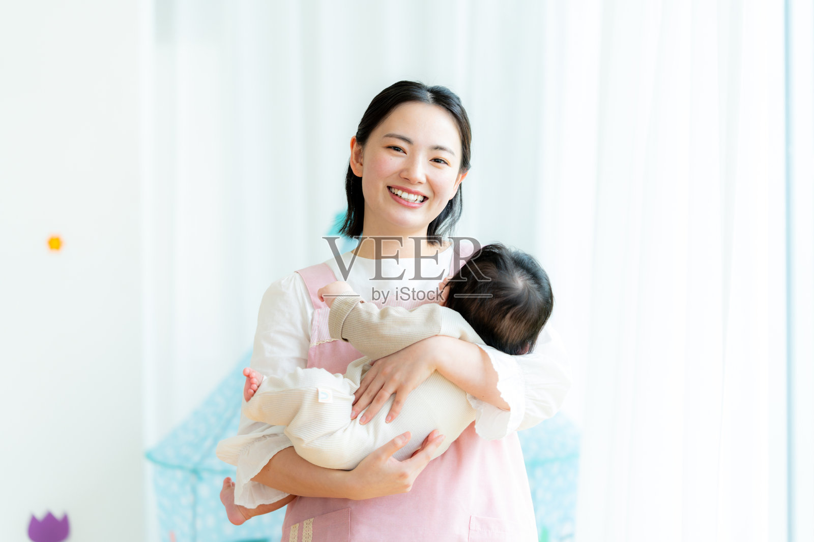 在幼儿园工作的儿童保育员照片摄影图片