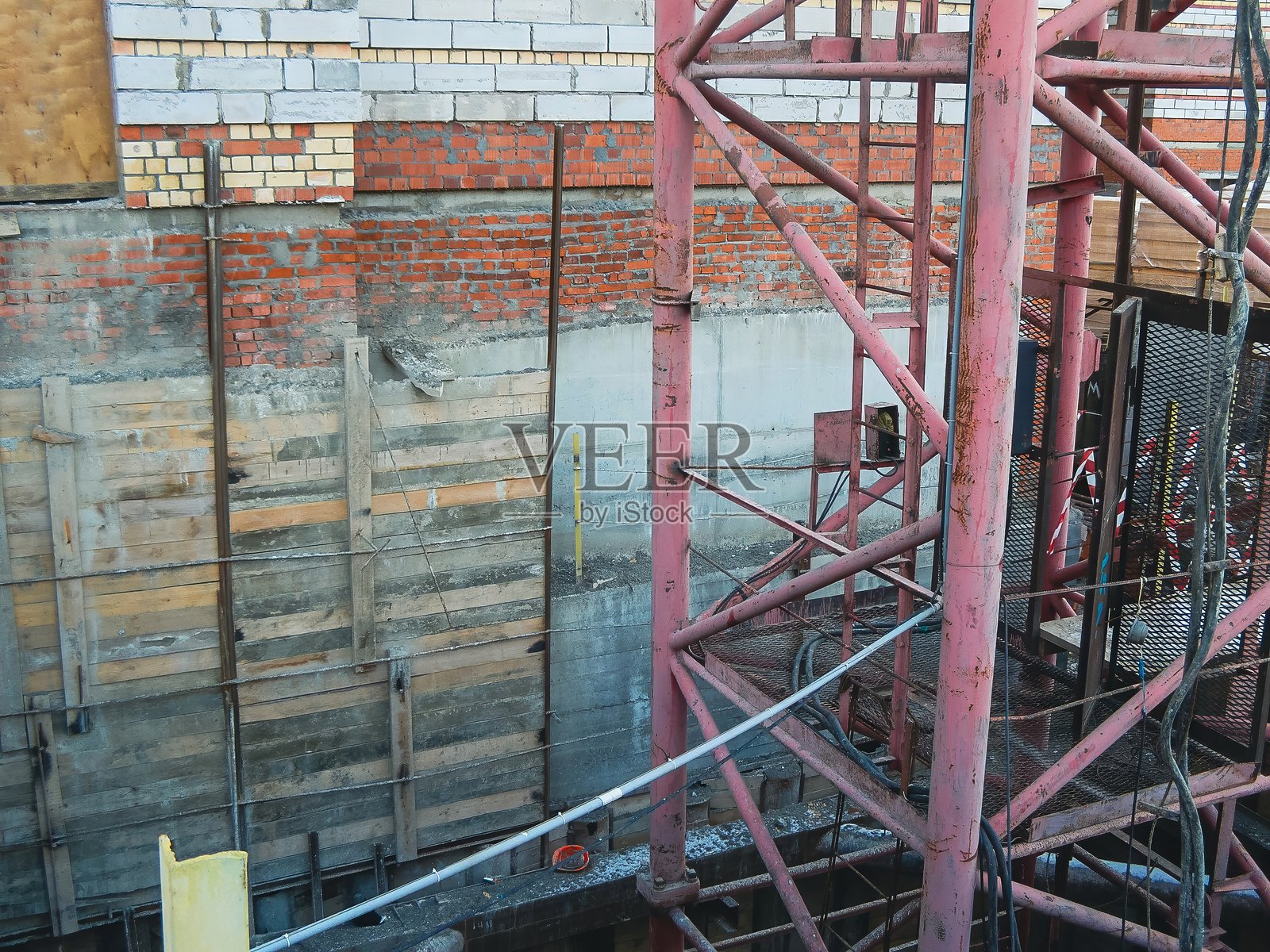 建筑工地展示了砖石和木材元素，上方有红色金属框架，从上方拍摄。照片摄影图片