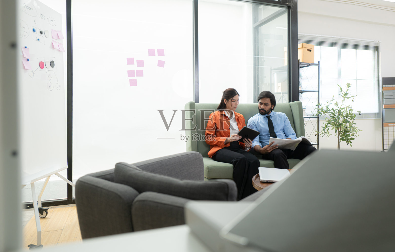 在现代办公室里，两位年轻企业家正在努力产生创意并建立商业项目。照片摄影图片